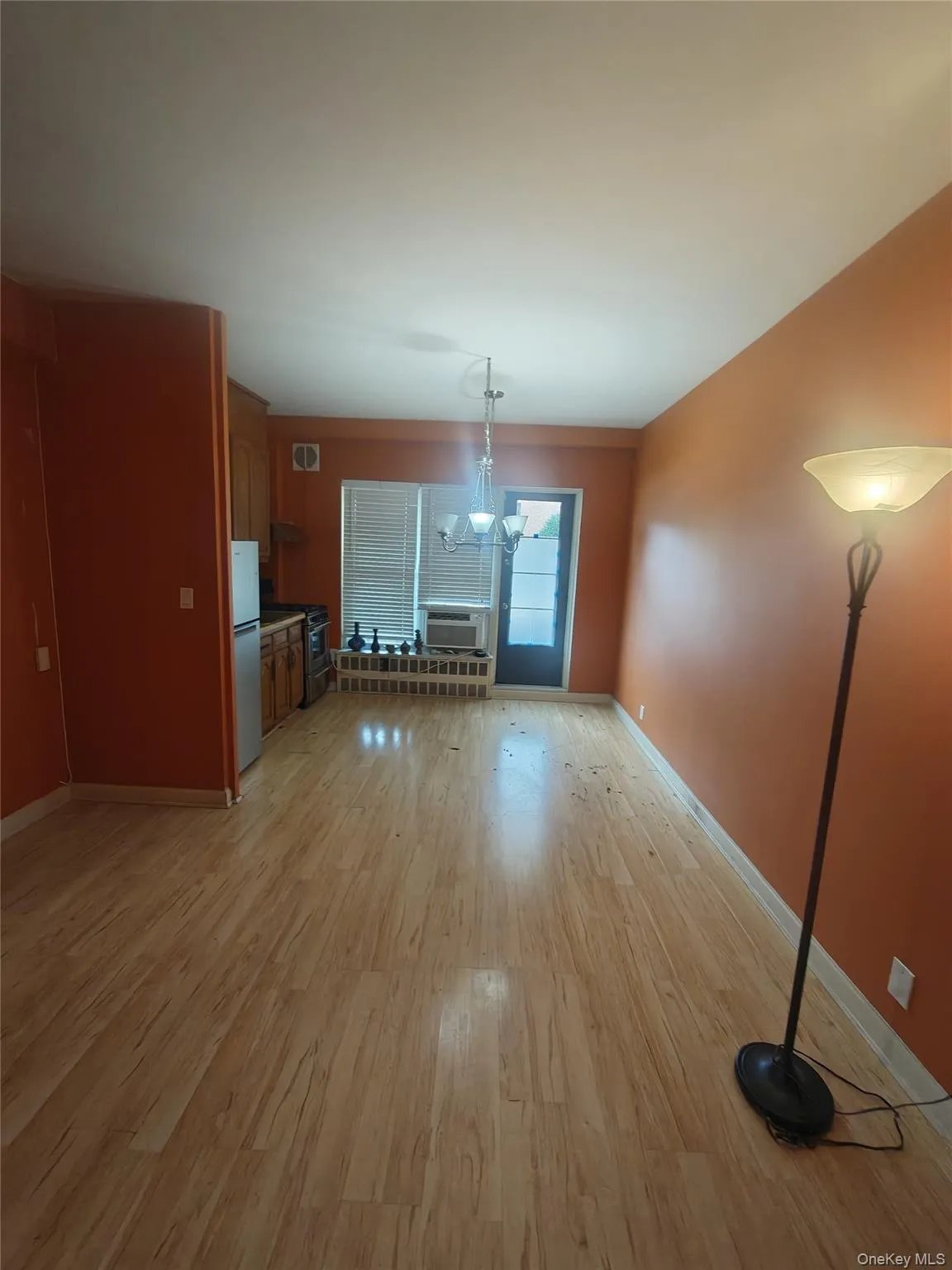 Unfurnished living room featuring light wood-style floors, a chandelier, and cooling unit Unfurnished living room featuring light wood-style floors, a chandelier, and cooling unit