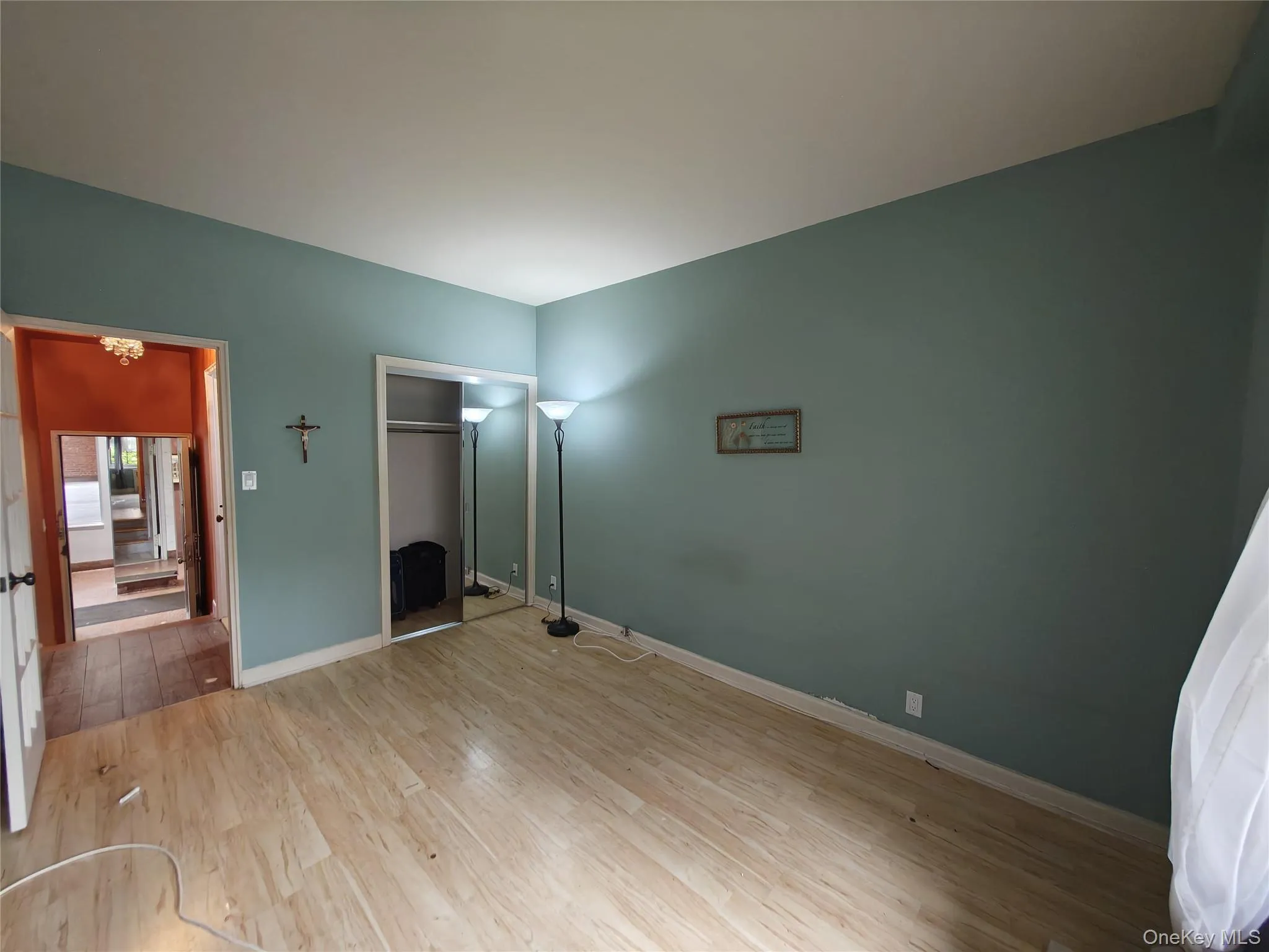 Unfurnished bedroom featuring light wood-type flooring, a closet, and a chandelier Unfurnished bedroom featuring light wood-type flooring, a closet, and a chandelier