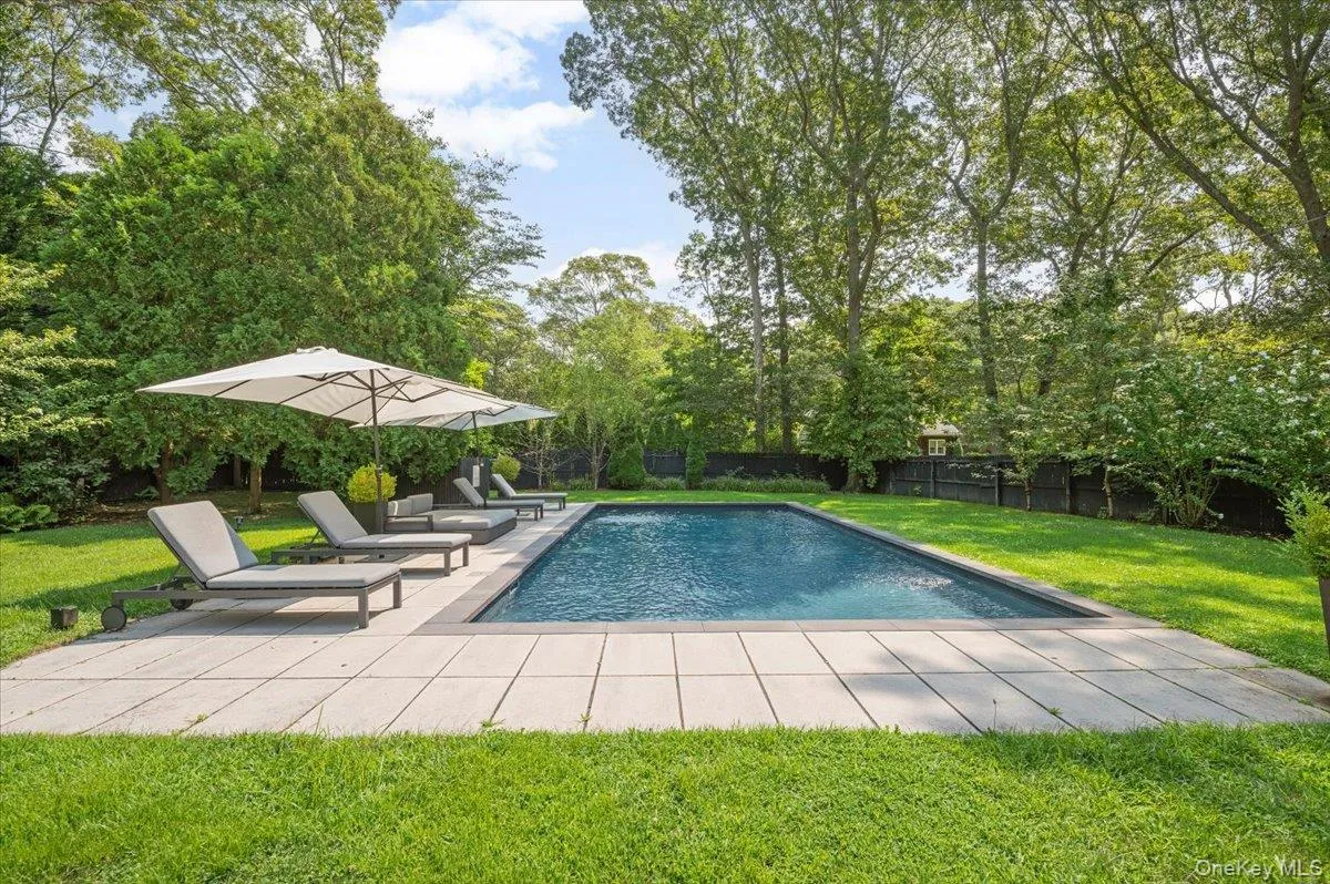 Swimming pool featuring a patio area, view of wooded area, and a fenced backyard Swimming pool featuring a patio area, view of wooded area, and a fenced backyard