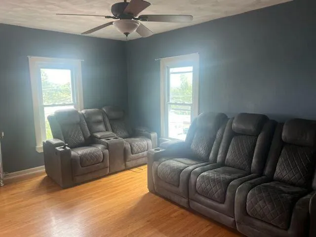 Living area featuring light wood finished floors and ceiling fan Living area featuring light wood finished floors and ceiling fan