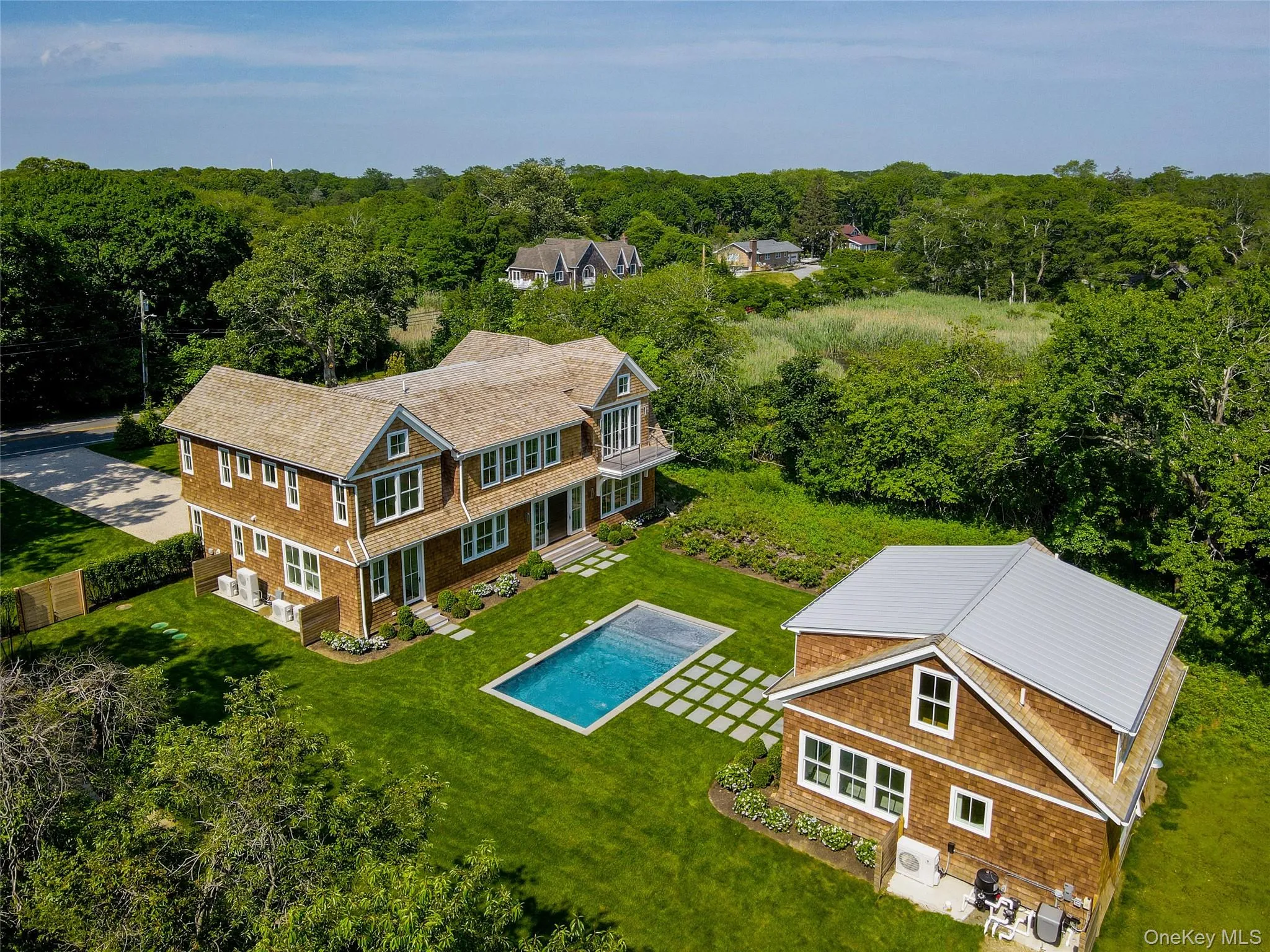 Sun-filled rear exterior view highlighting the exceptional scale and beauty of this new waterfront estate. Sun-filled rear exterior view highlighting the exceptional scale and beauty of this new waterfront estate.