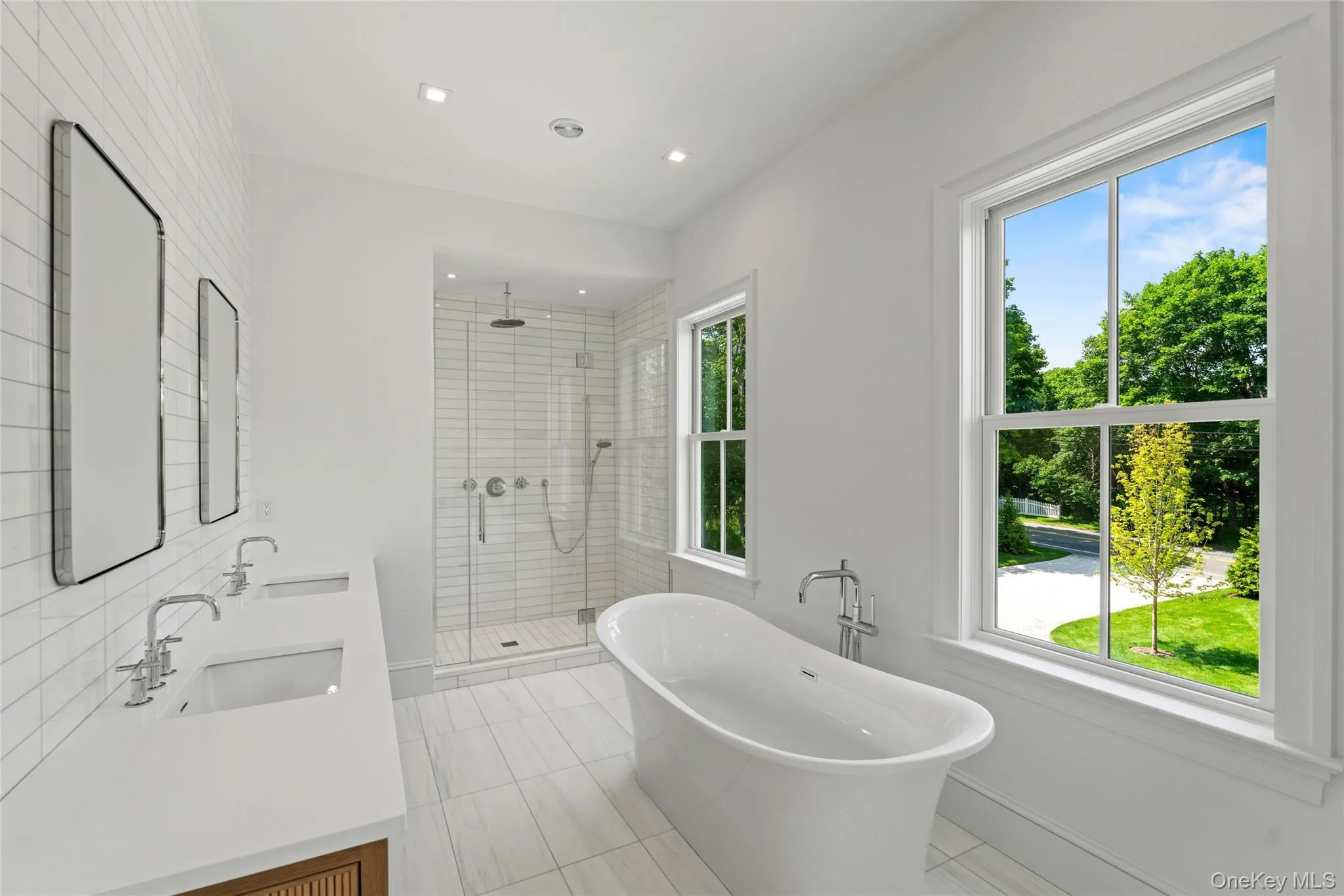 Bathroom featuring spacious stall shower, 9ft double vanity, oversized soaking tub, healthy amount of natural light, and recessed lighting Bathroom featuring spacious stall shower, 9ft double vanity, oversized soaking tub, healthy amount of natural light, and recessed lighting
