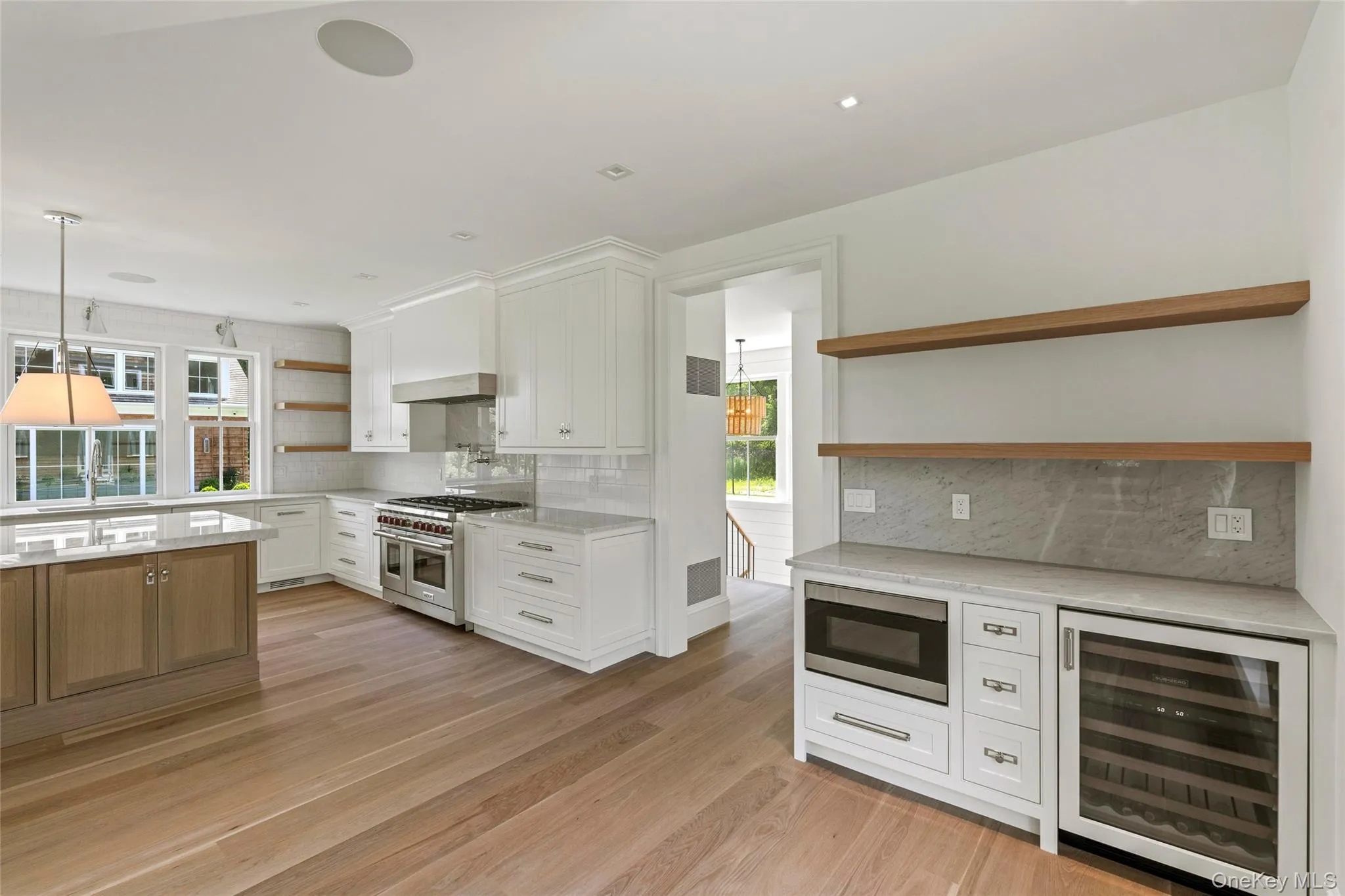 Kitchen featuring open shelves, wine cooler, appliances with stainless steel finishes, and tasteful backsplash Kitchen featuring open shelves, wine cooler, appliances with stainless steel finishes, and tasteful backsplash