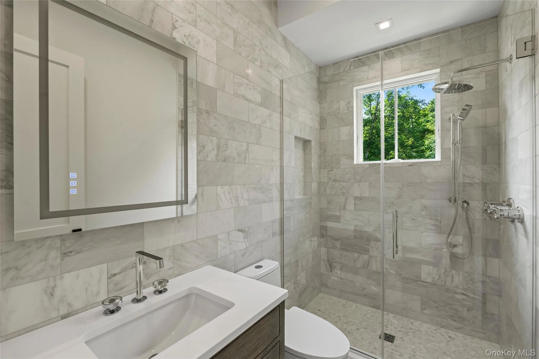 Bathroom featuring vanity, a shower stall, and tile walls Bathroom featuring vanity, a shower stall, and tile walls