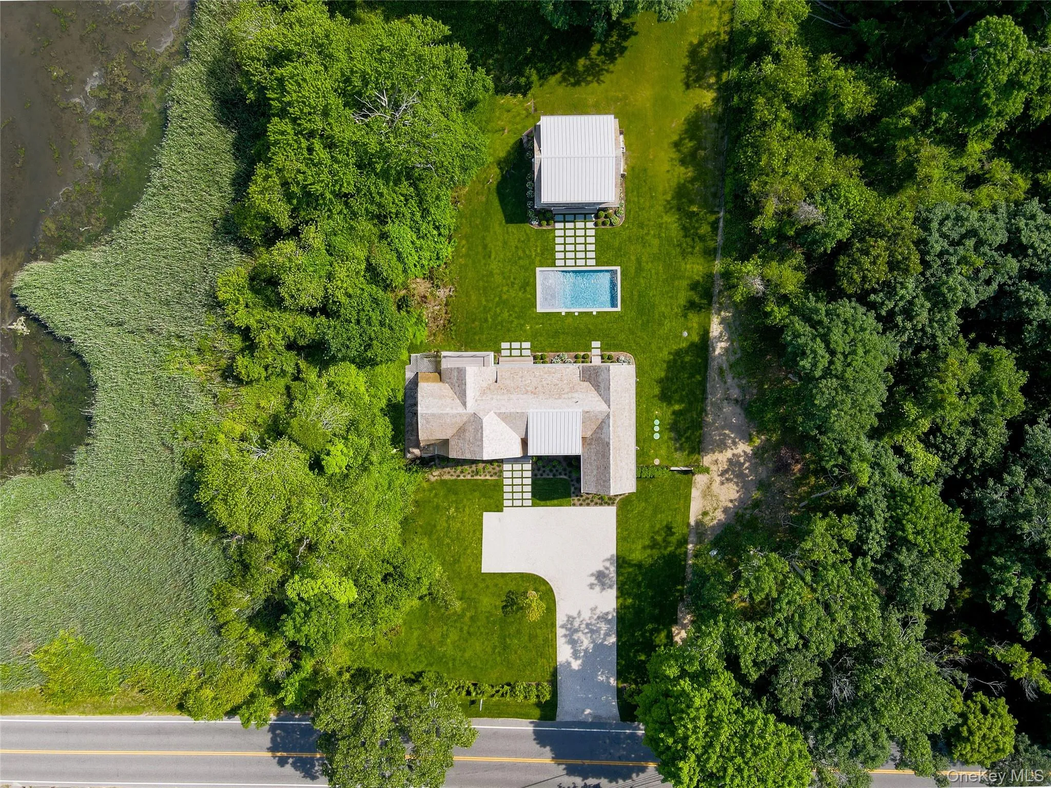 Birds-eye aerial view of this unique offering, capturing the expansive grounds in full scale with lush greenery and privacy surrounding this exceptional waterfront estate. Birds-eye aerial view of this unique offering, capturing the expansive grounds in full scale with lush greenery and privacy surrounding this exceptional waterfront estate.