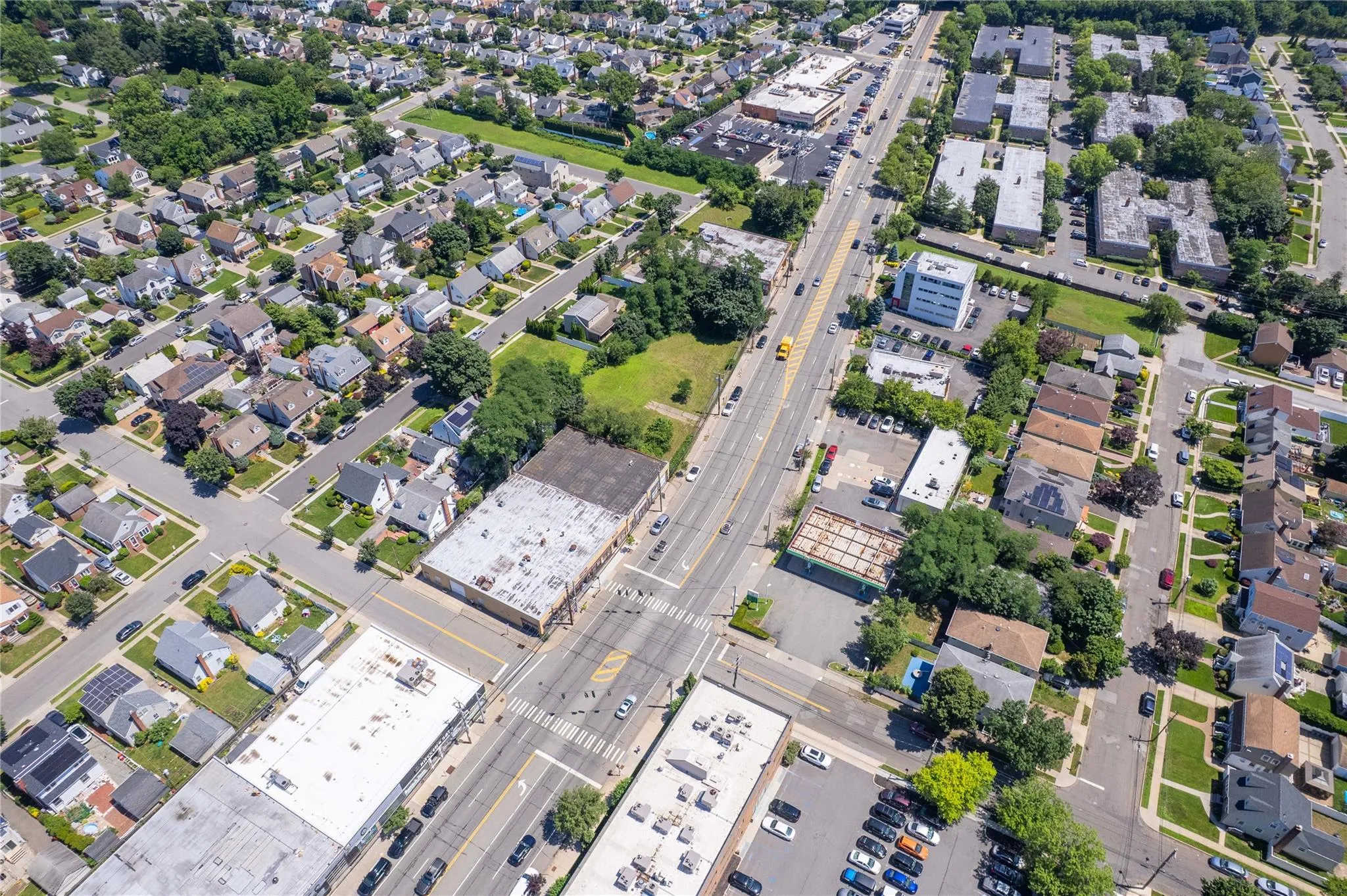 Aerial view of property and surrounding area featuring a main thoroughfare Aerial view of property and surrounding area featuring a main thoroughfare