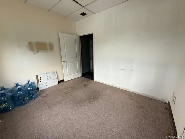Carpeted spare room featuring a drop ceiling Carpeted spare room featuring a drop ceiling