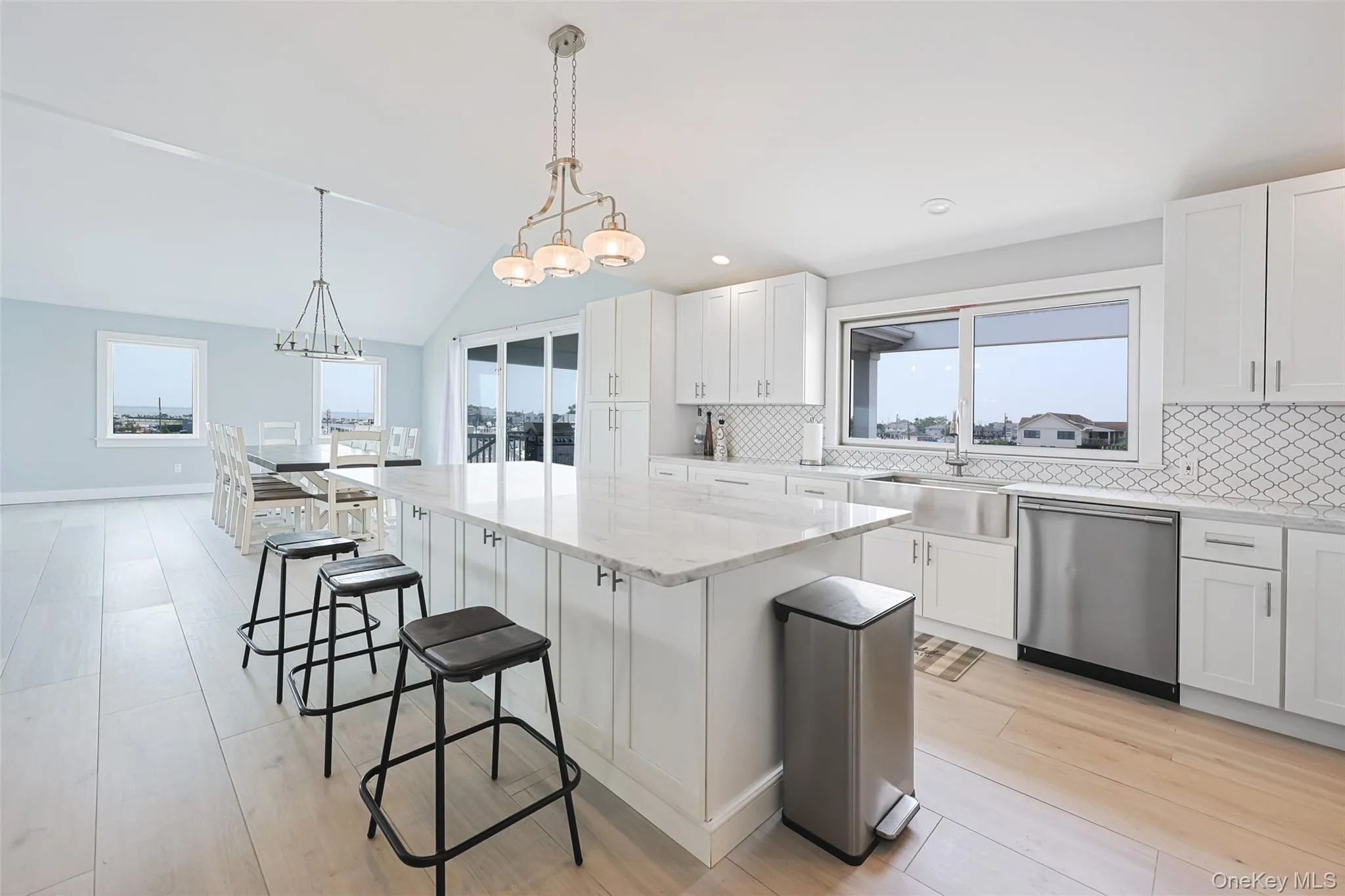 Kitchen with dishwasher, a kitchen bar, healthy amount of natural light, vaulted ceiling, and recessed lighting Kitchen with dishwasher, a kitchen bar, healthy amount of natural light, vaulted ceiling, and recessed lighting