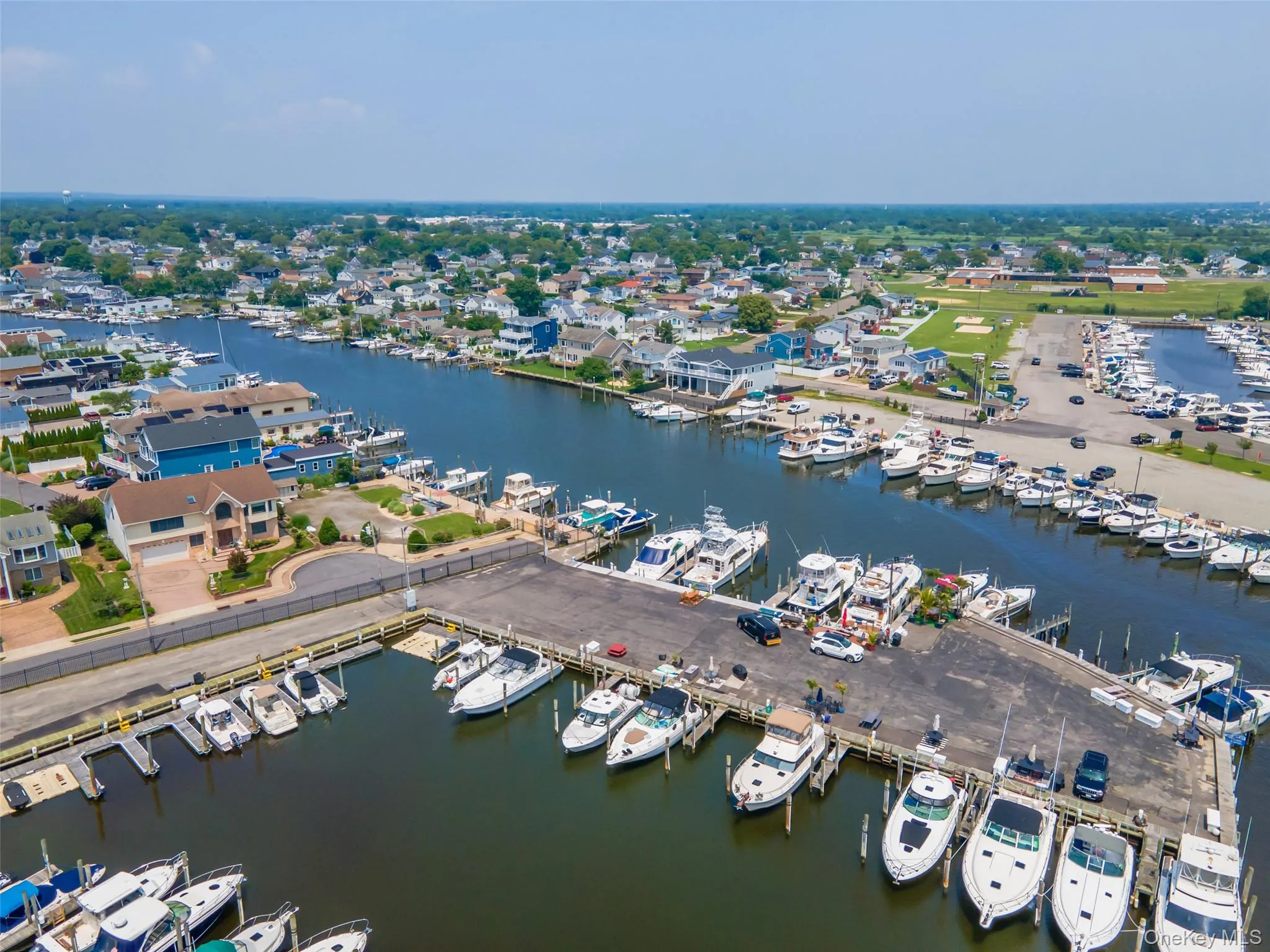 Bird's eye view of numerous boat docks and a nearby body of water Bird's eye view of numerous boat docks and a nearby body of water