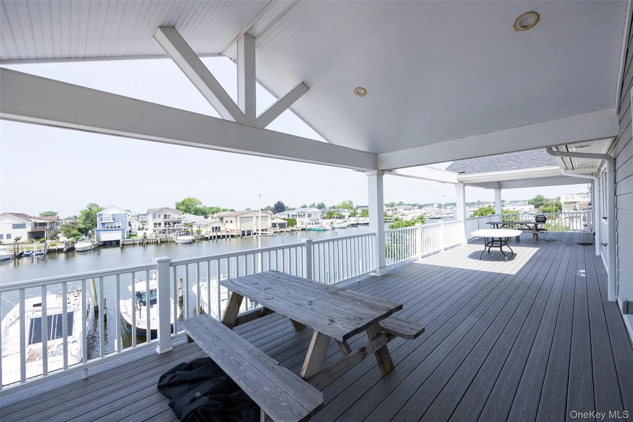 Wooden terrace featuring outdoor dining space, a water view, and a residential view Wooden terrace featuring outdoor dining space, a water view, and a residential view