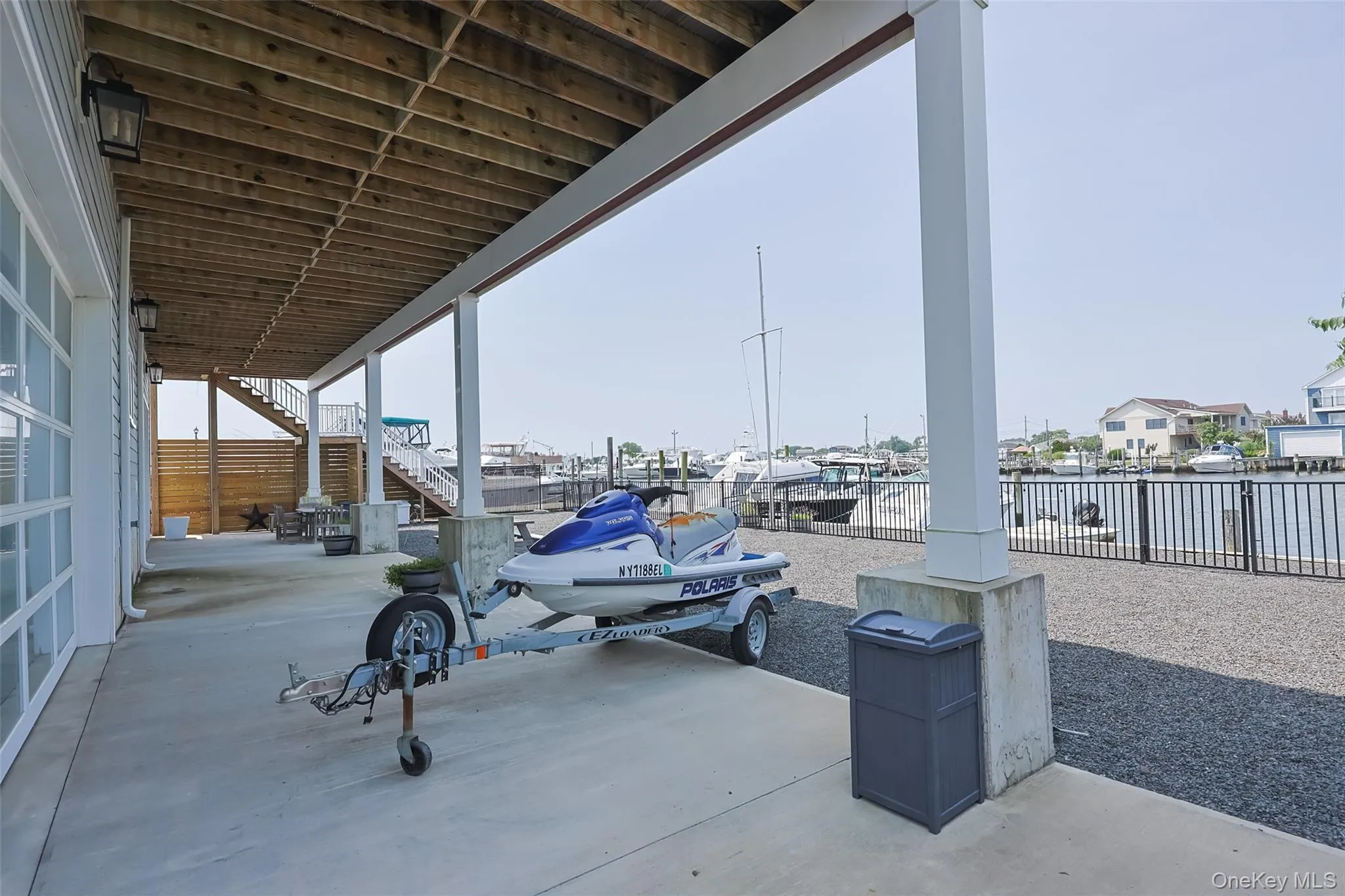 View of patio featuring stairs, a water view, a dock, and boat lift View of patio featuring stairs, a water view, a dock, and boat lift