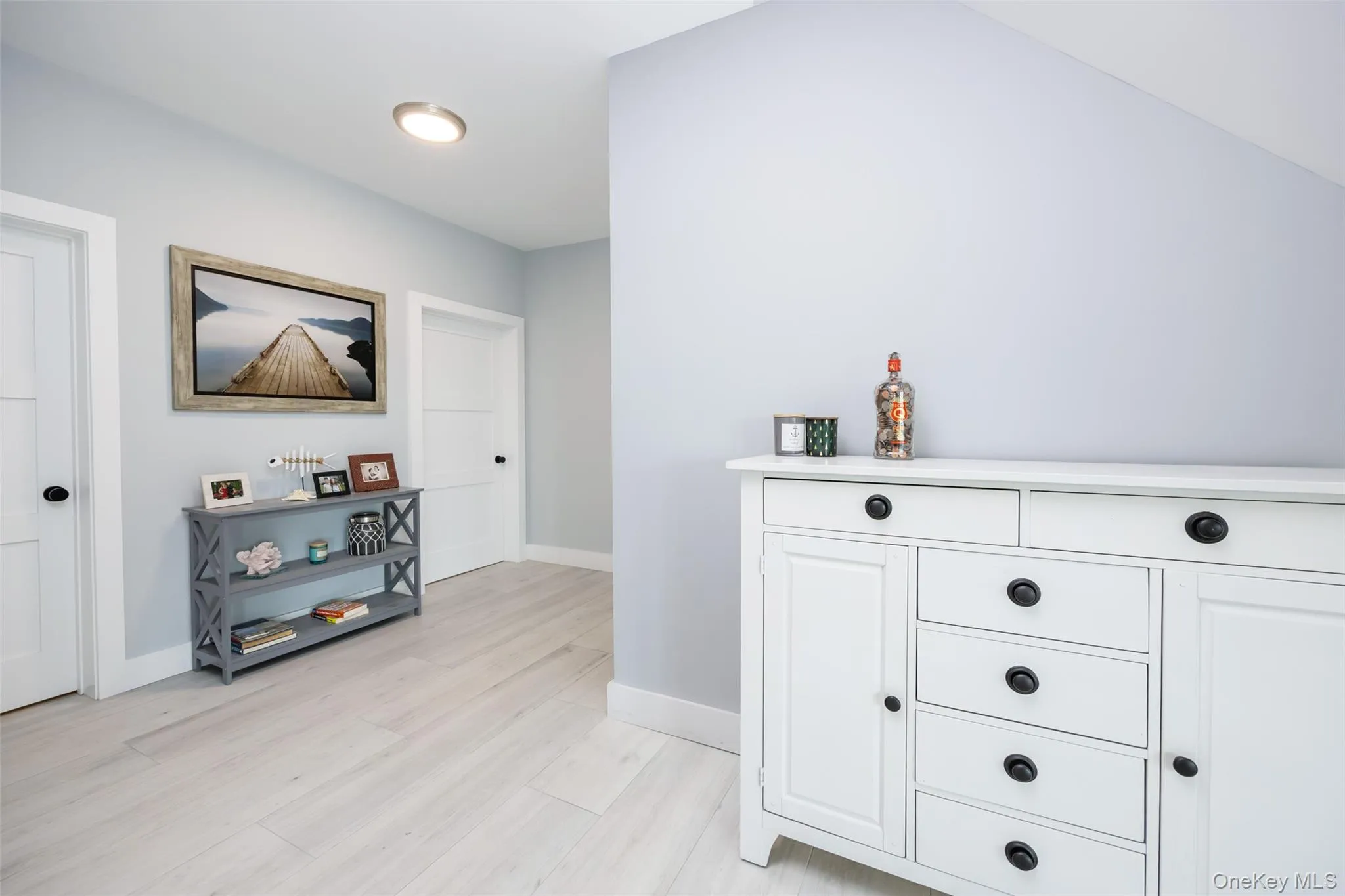 Hallway with baseboards and light wood finished floors Hallway with baseboards and light wood finished floors