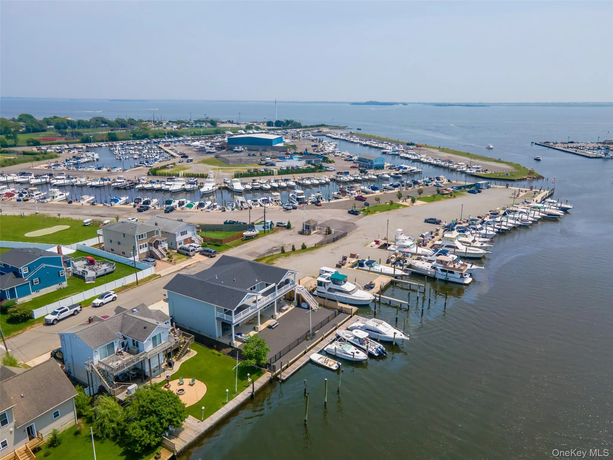 Drone / aerial view of numerous boat docks and a nearby body of water Drone / aerial view of numerous boat docks and a nearby body of water