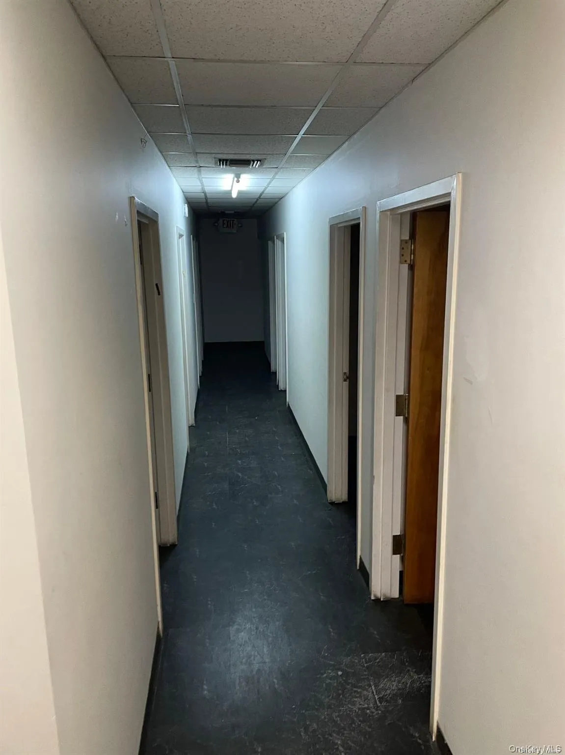 Hallway featuring concrete floors and a drop ceiling Hallway featuring concrete floors and a drop ceiling