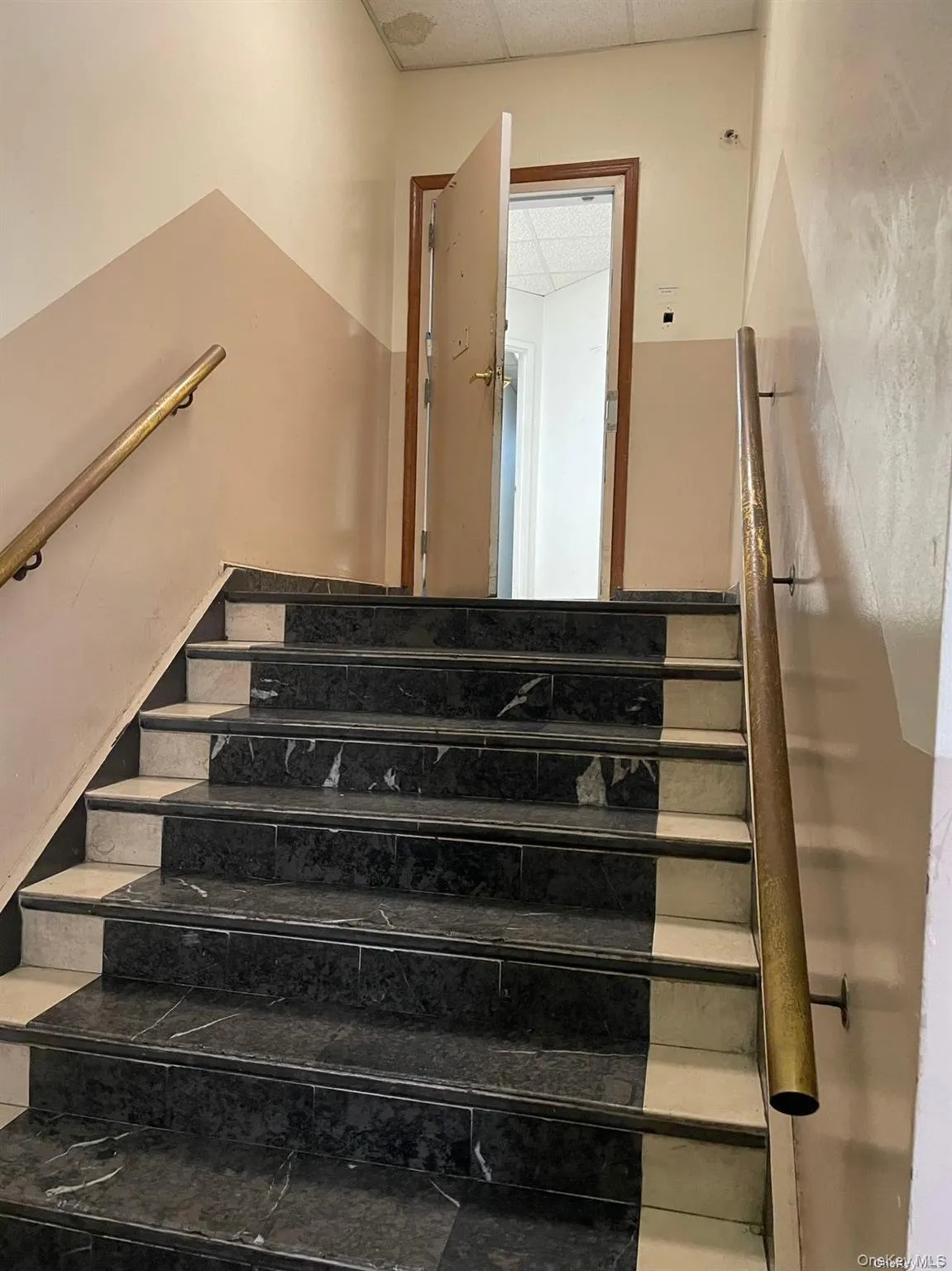 Staircase featuring a drop ceiling Staircase featuring a drop ceiling