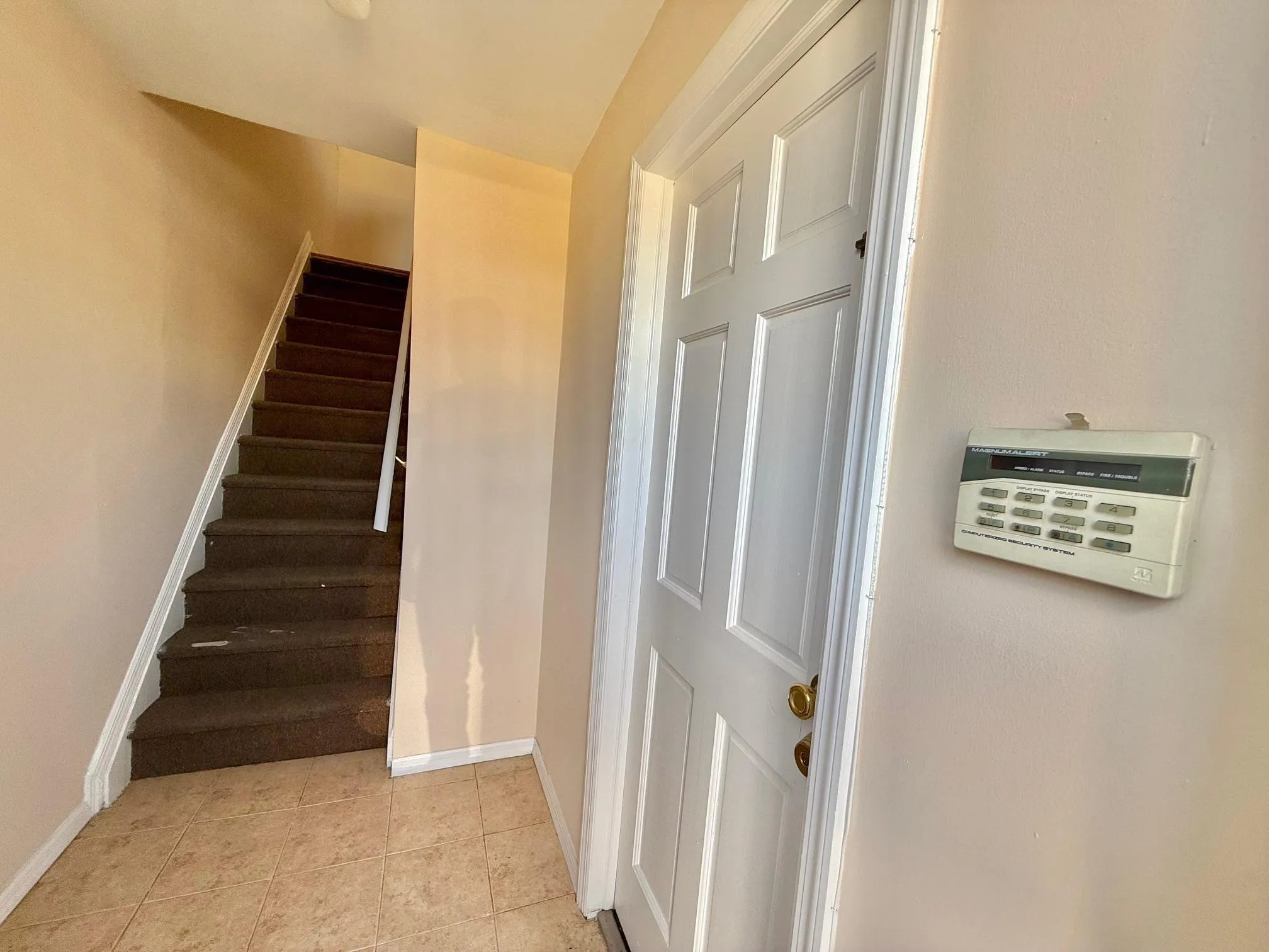 Staircase featuring baseboards and tile patterned flooring Staircase featuring baseboards and tile patterned flooring