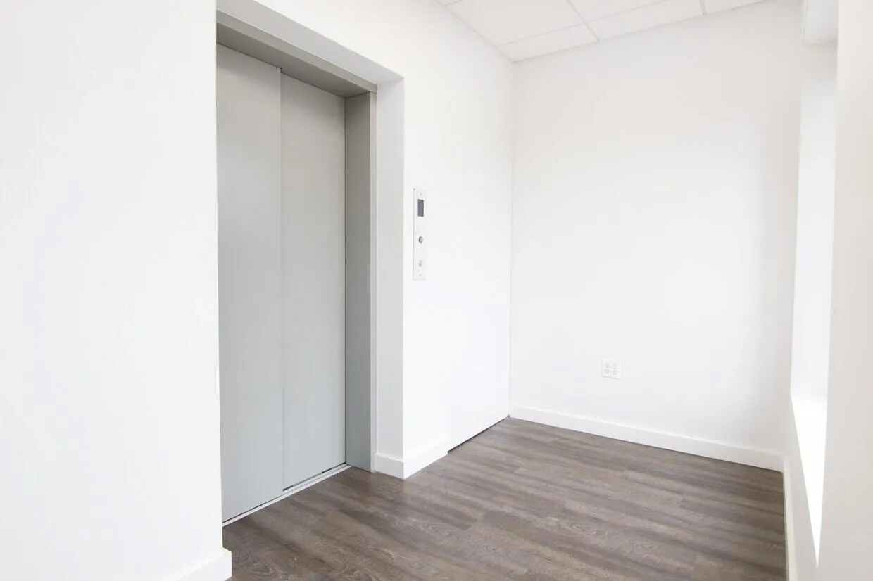 Spare room featuring elevator, a drop ceiling, and dark wood-type flooring Spare room featuring elevator, a drop ceiling, and dark wood-type flooring