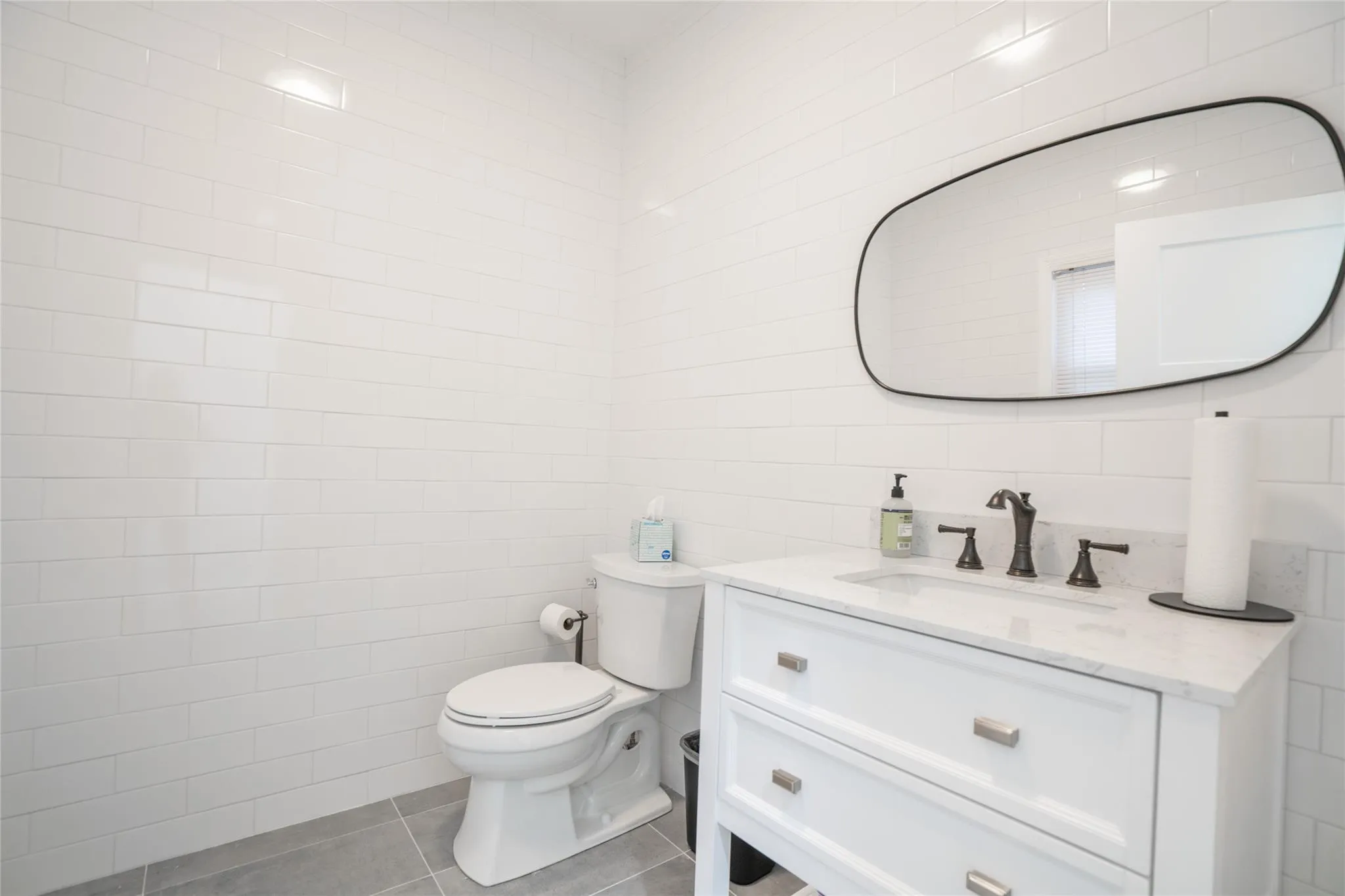 Half bath with tile walls, vanity, and tile patterned flooring Half bath with tile walls, vanity, and tile patterned flooring