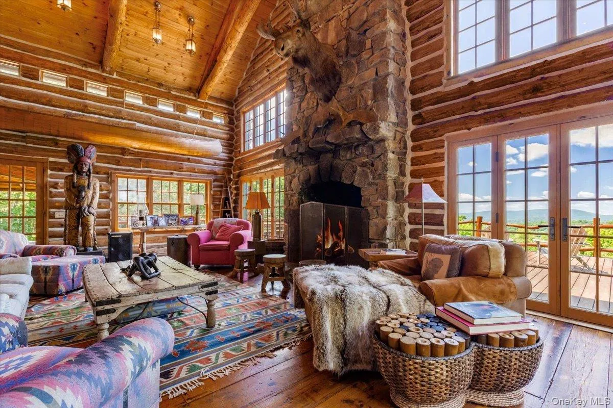 Living area with high vaulted ceiling, rustic walls, hardwood / wood-style floors, a wood ceiling with exposed beams, and french doors Living area with high vaulted ceiling, rustic walls, hardwood / wood-style floors, a wood ceiling with exposed beams, and french doors