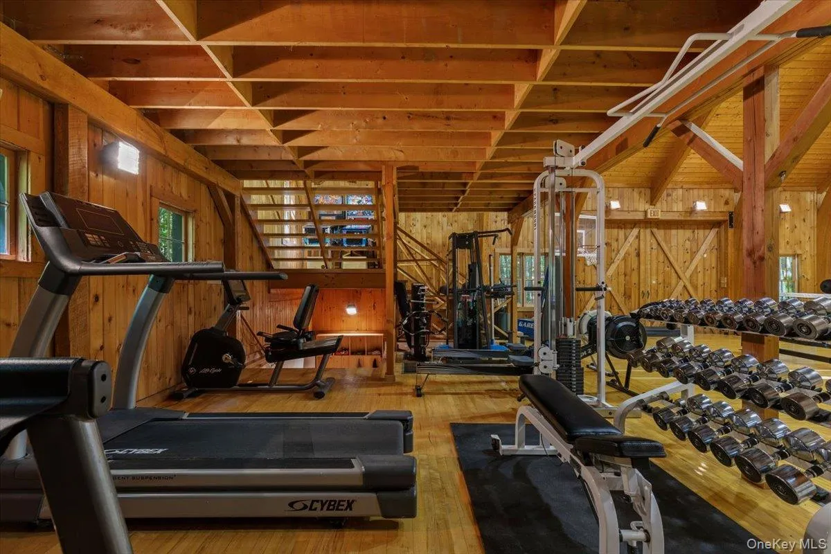 Workout area with wooden walls, hardwood / wood-style floors, and plenty of natural light Workout area with wooden walls, hardwood / wood-style floors, and plenty of natural light