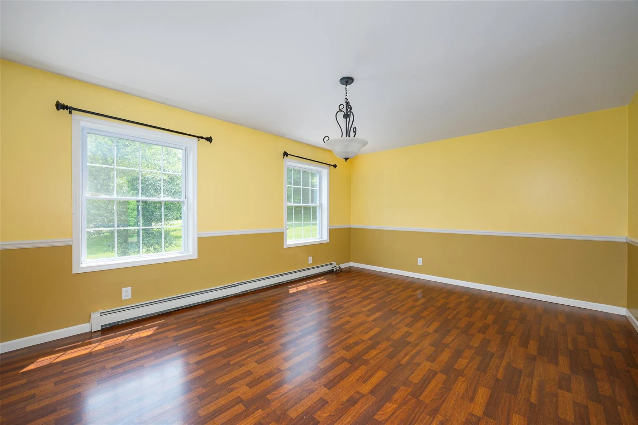 Spare room featuring a baseboard radiator and dark wood-style flooring Spare room featuring a baseboard radiator and dark wood-style flooring