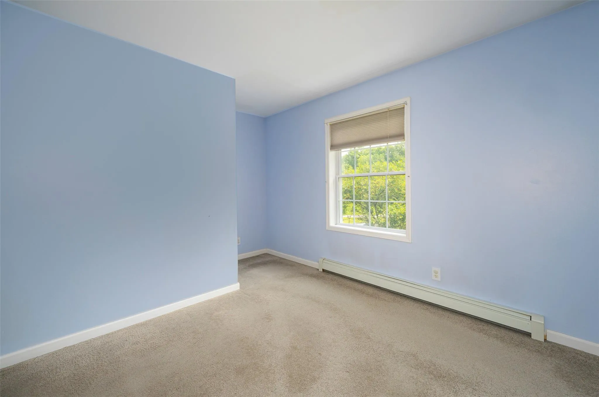 Carpeted empty room with a baseboard heating unit and baseboards Carpeted empty room with a baseboard heating unit and baseboards