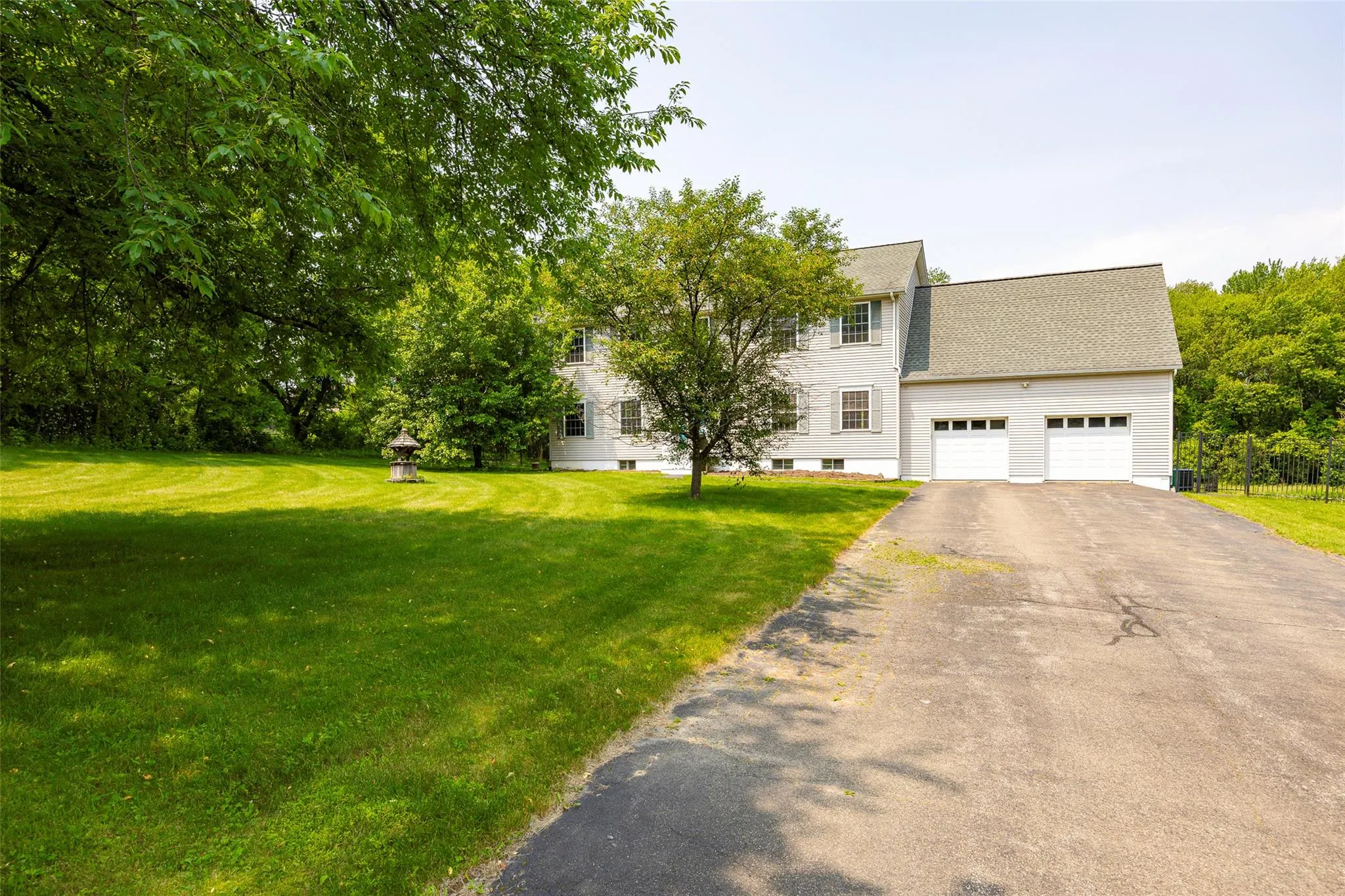 Colonial house with asphalt driveway, a garage, a front lawn, and roof with shingles Colonial house with asphalt driveway, a garage, a front lawn, and roof with shingles