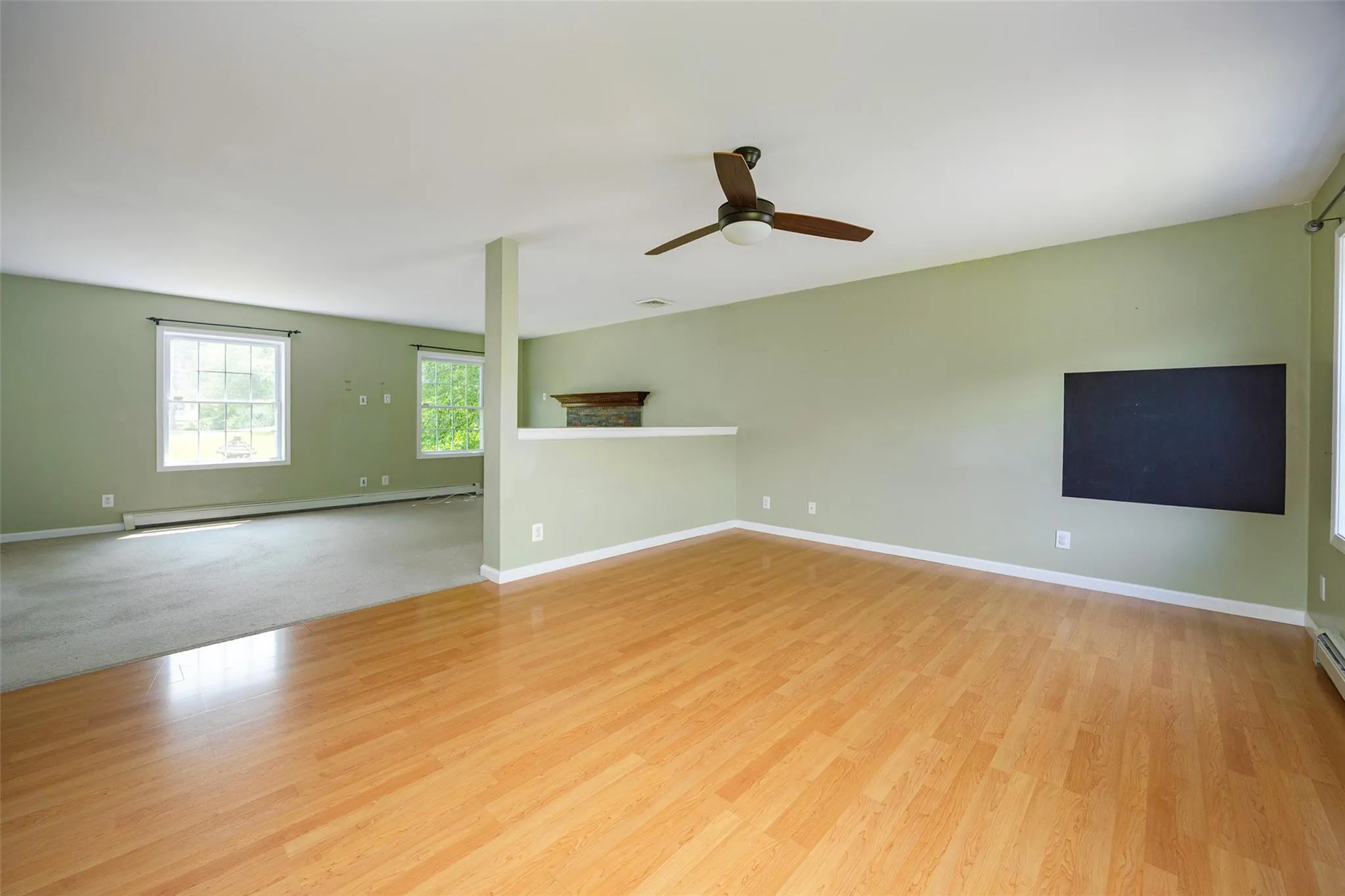Unfurnished room featuring a baseboard radiator, a ceiling fan, and wood finished floors Unfurnished room featuring a baseboard radiator, a ceiling fan, and wood finished floors