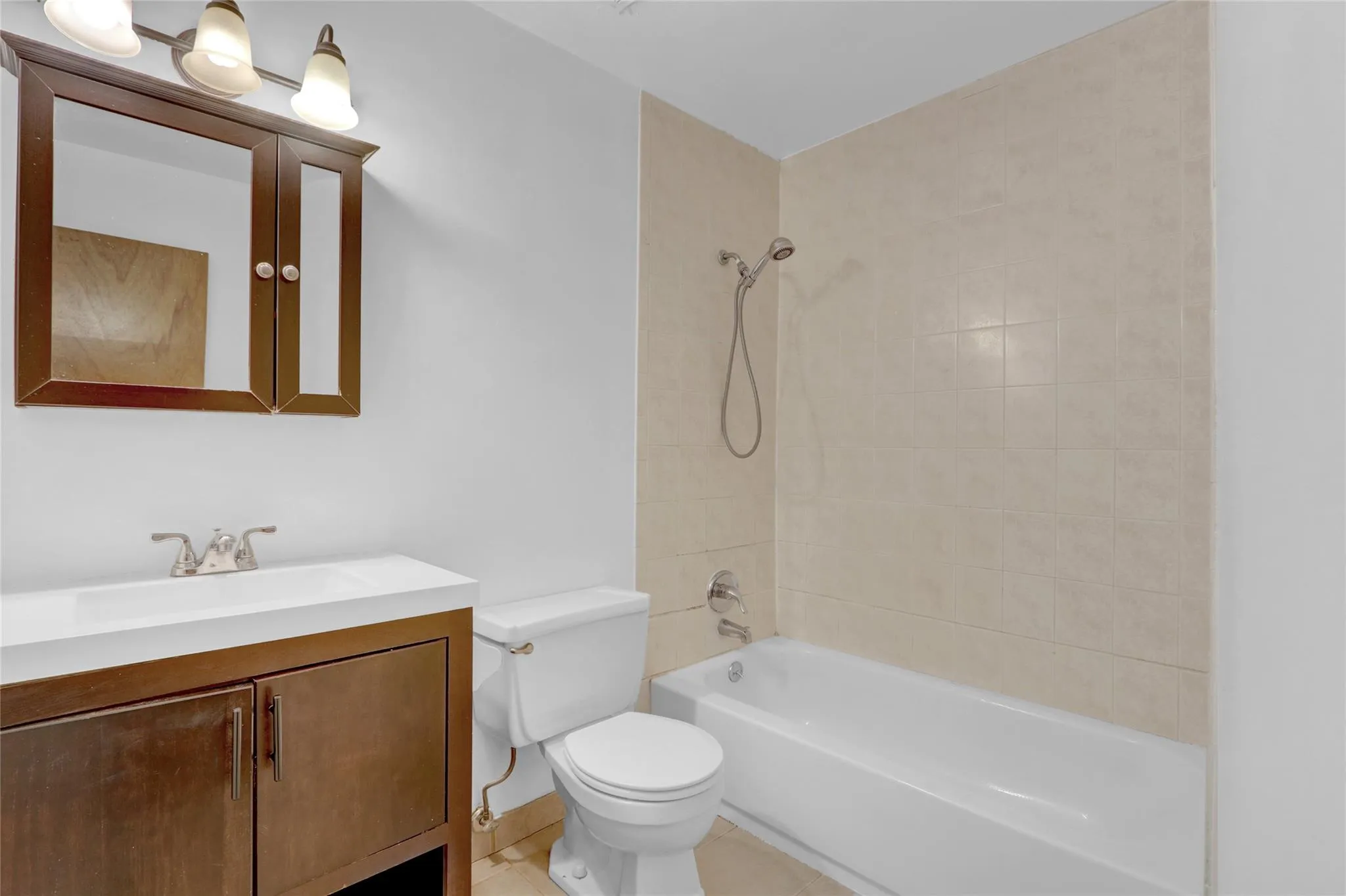 Bathroom featuring vanity, tub / shower combination, and tile patterned floors Bathroom featuring vanity, tub / shower combination, and tile patterned floors
