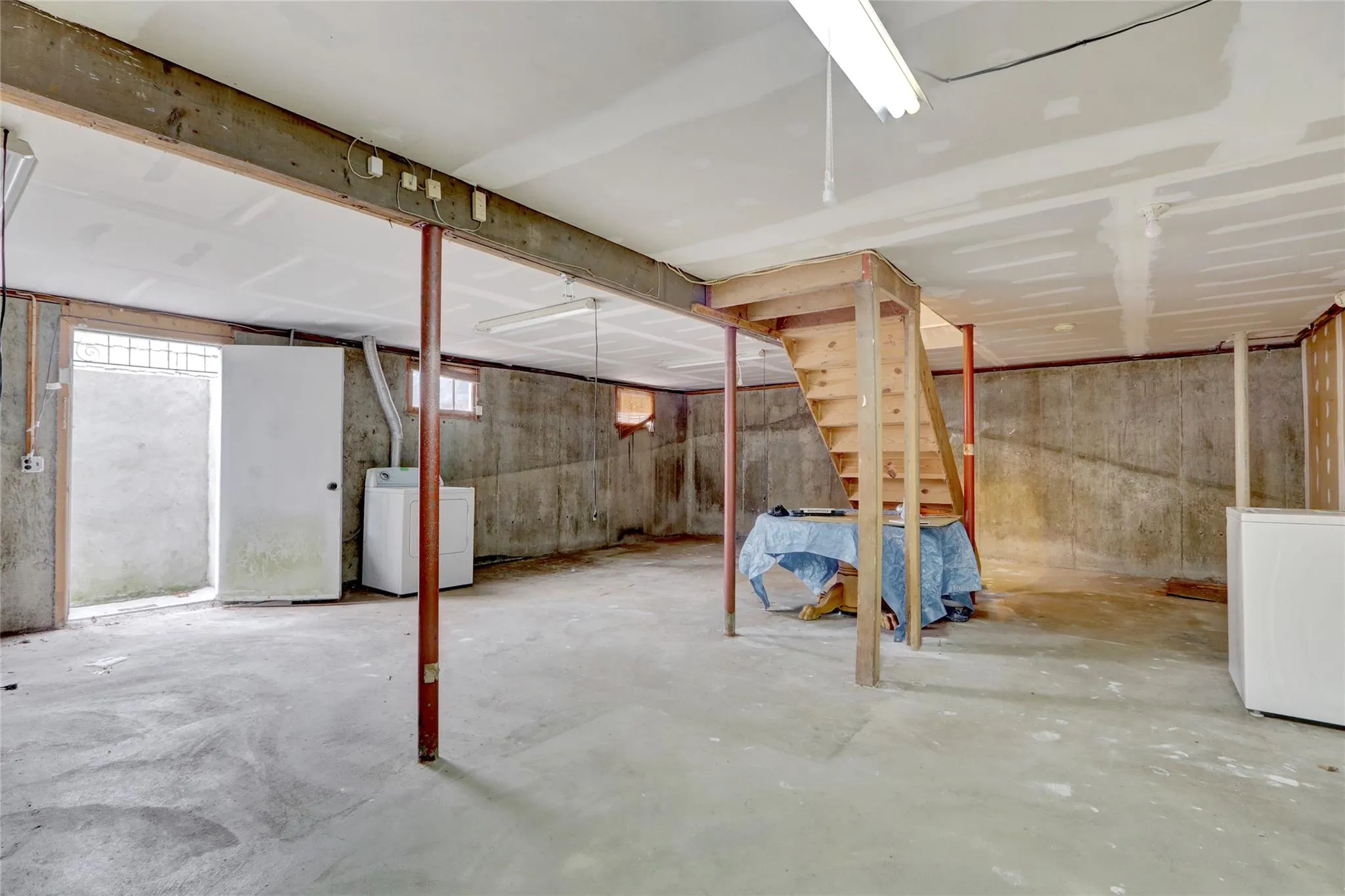Below grade area with washer / dryer and refrigerator Below grade area with washer / dryer and refrigerator