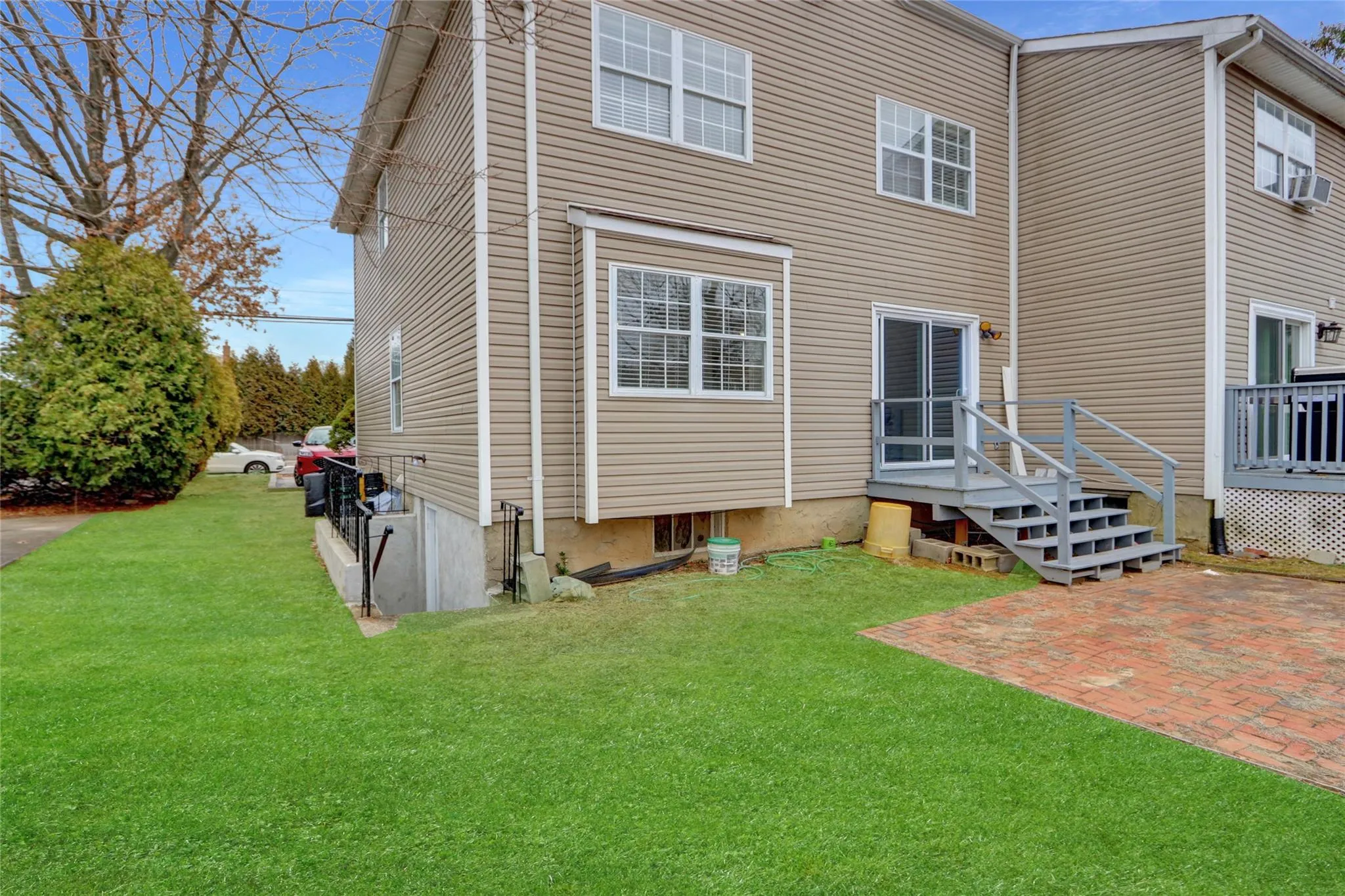 Back of house with a patio, a lawn, and a deck Back of house with a patio, a lawn, and a deck