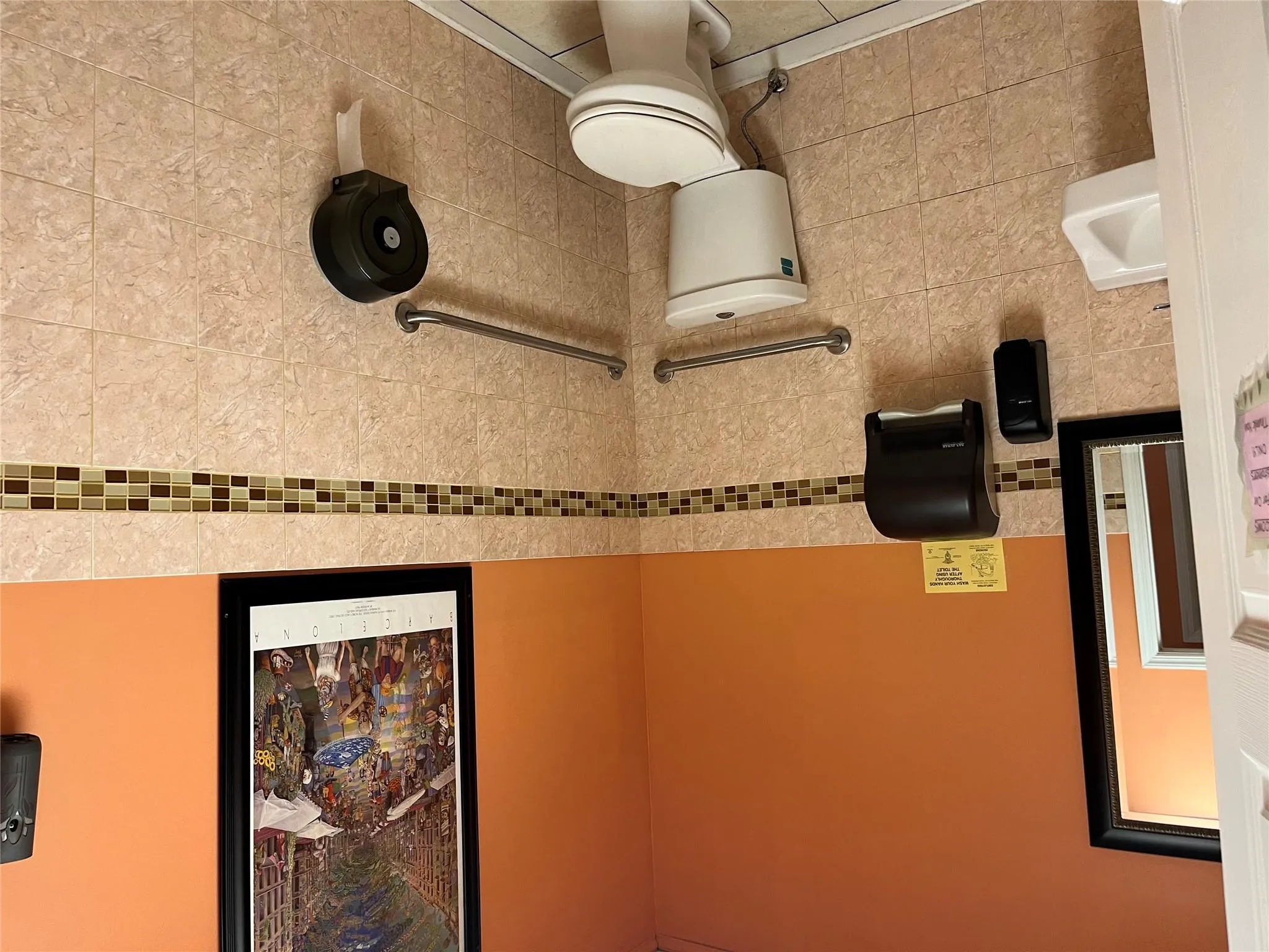 Half bath with tile walls, a wainscoted wall, and tile patterned floors Half bath with tile walls, a wainscoted wall, and tile patterned floors