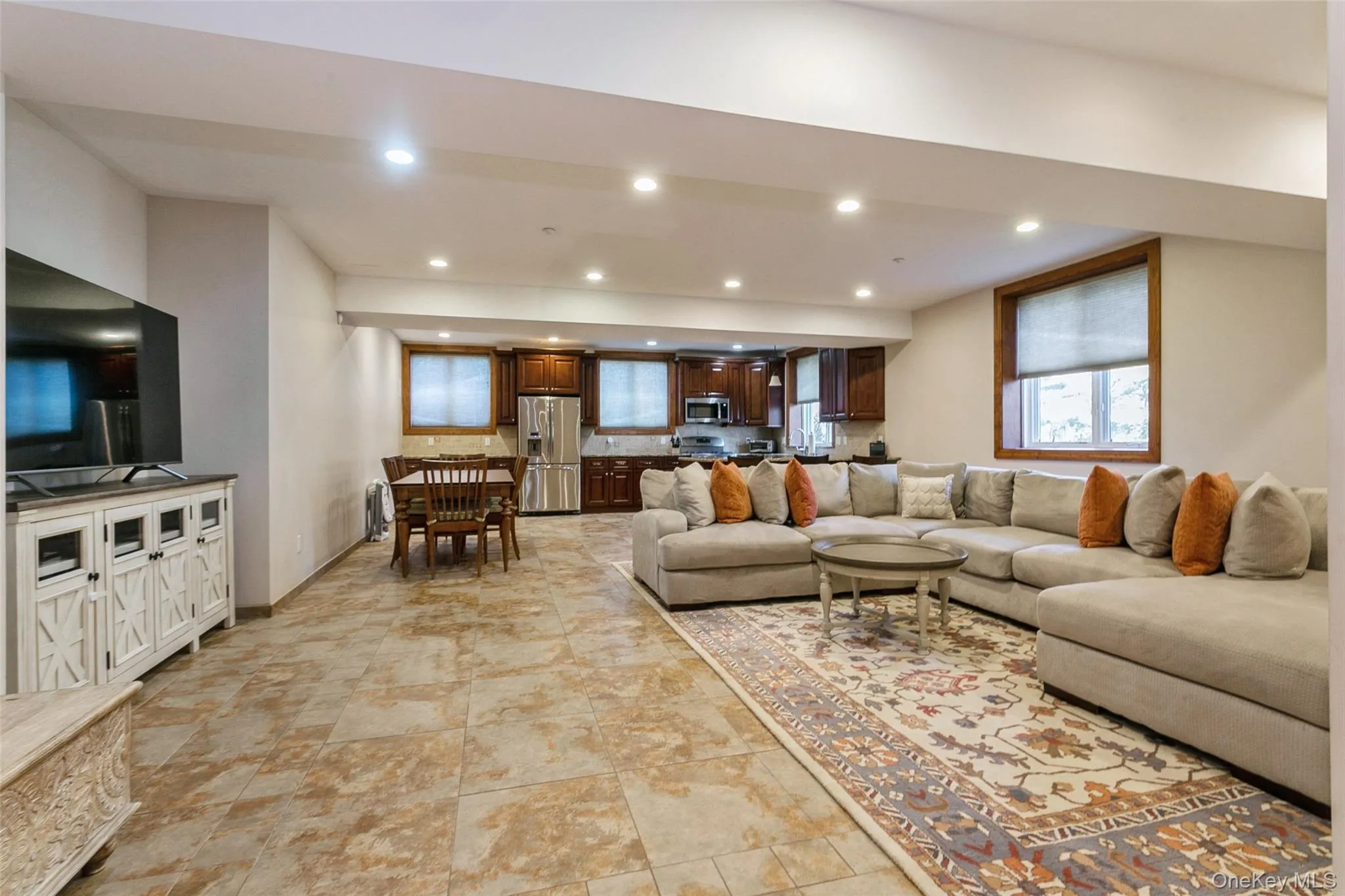 Living area with recessed lighting and light stone finish flooring Living area with recessed lighting and light stone finish flooring