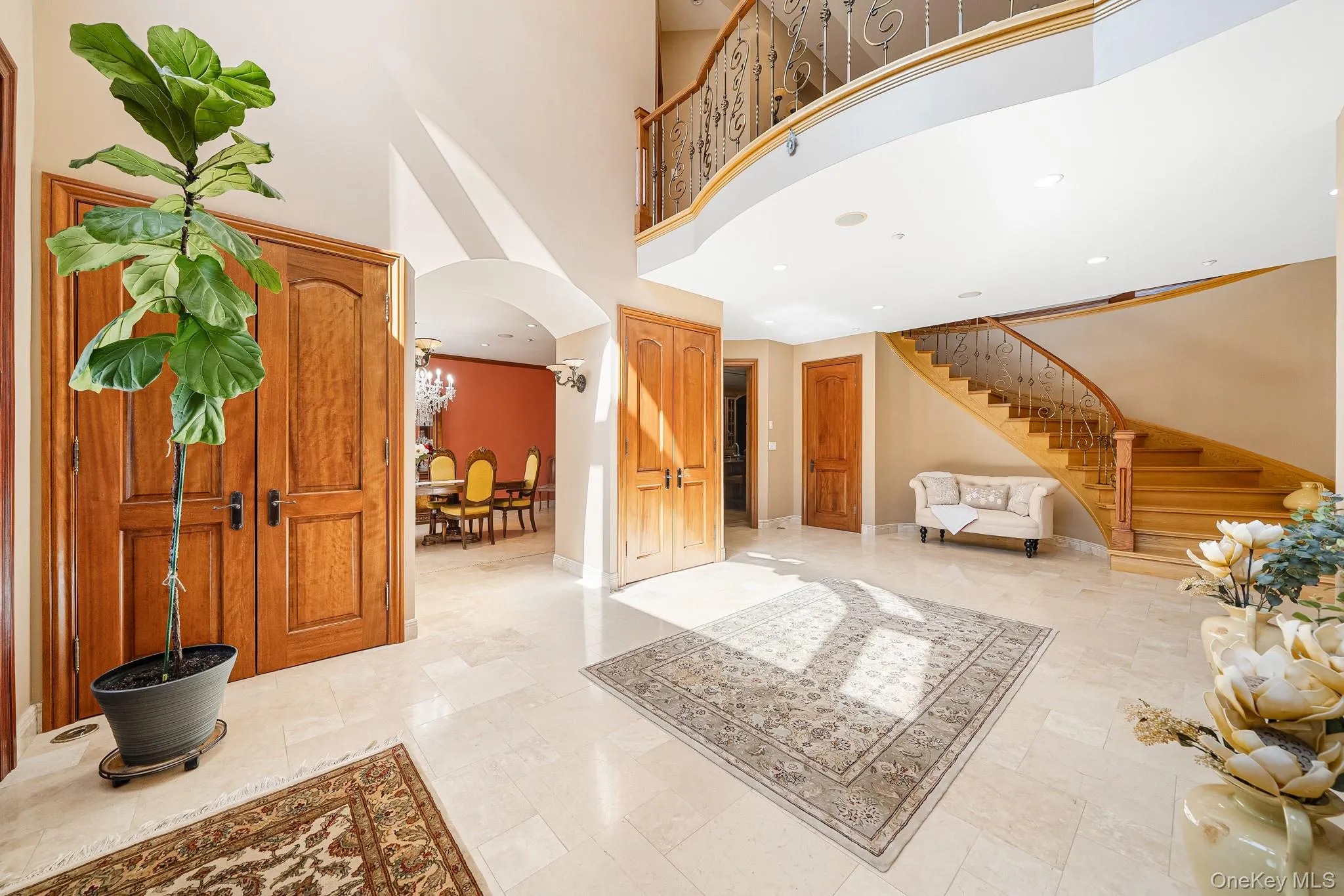 Entryway featuring stairs, arched walkways, and a towering ceiling Entryway featuring stairs, arched walkways, and a towering ceiling