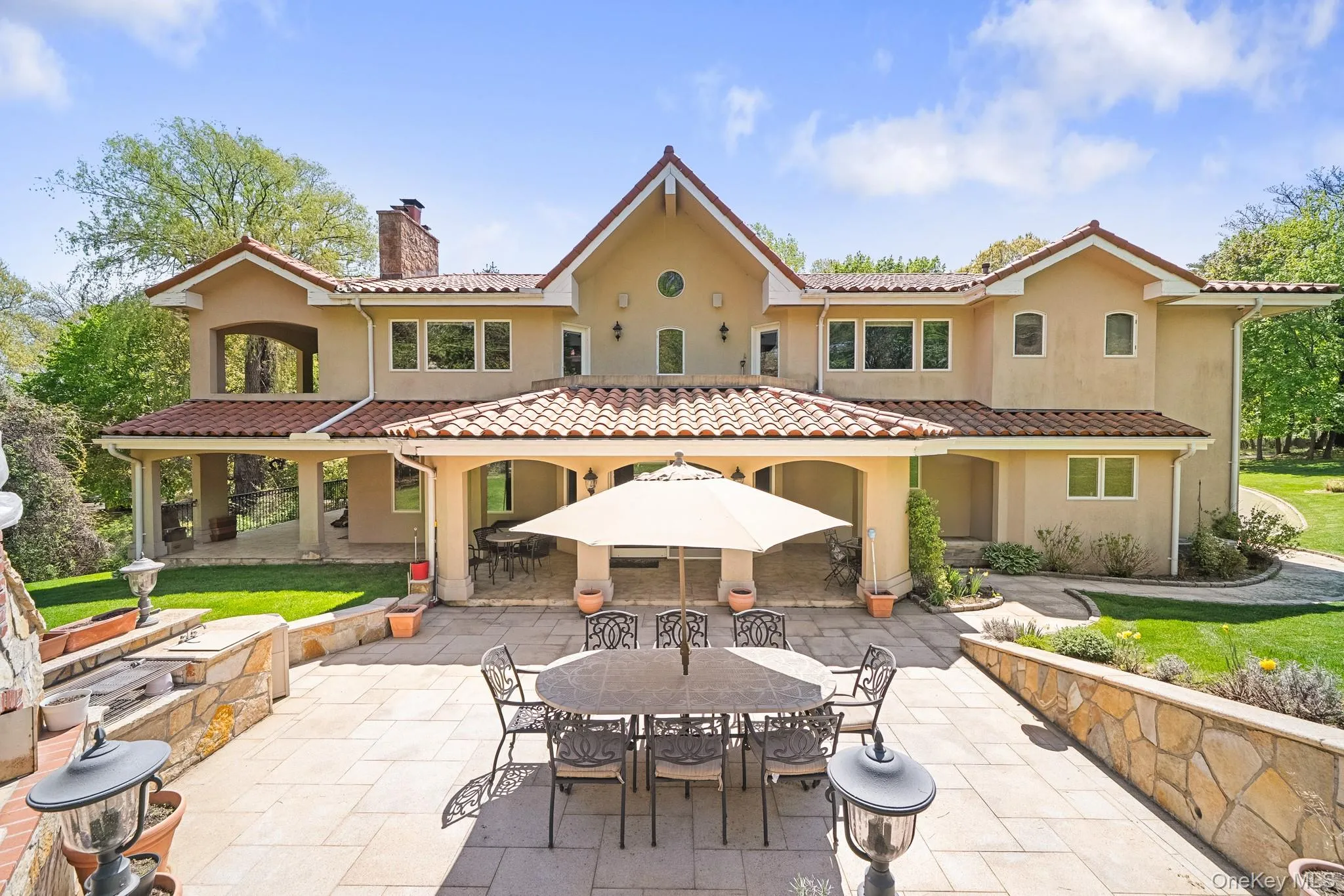 Rear view of house with a chimney, a patio, outdoor dining space, and stucco siding Rear view of house with a chimney, a patio, outdoor dining space, and stucco siding