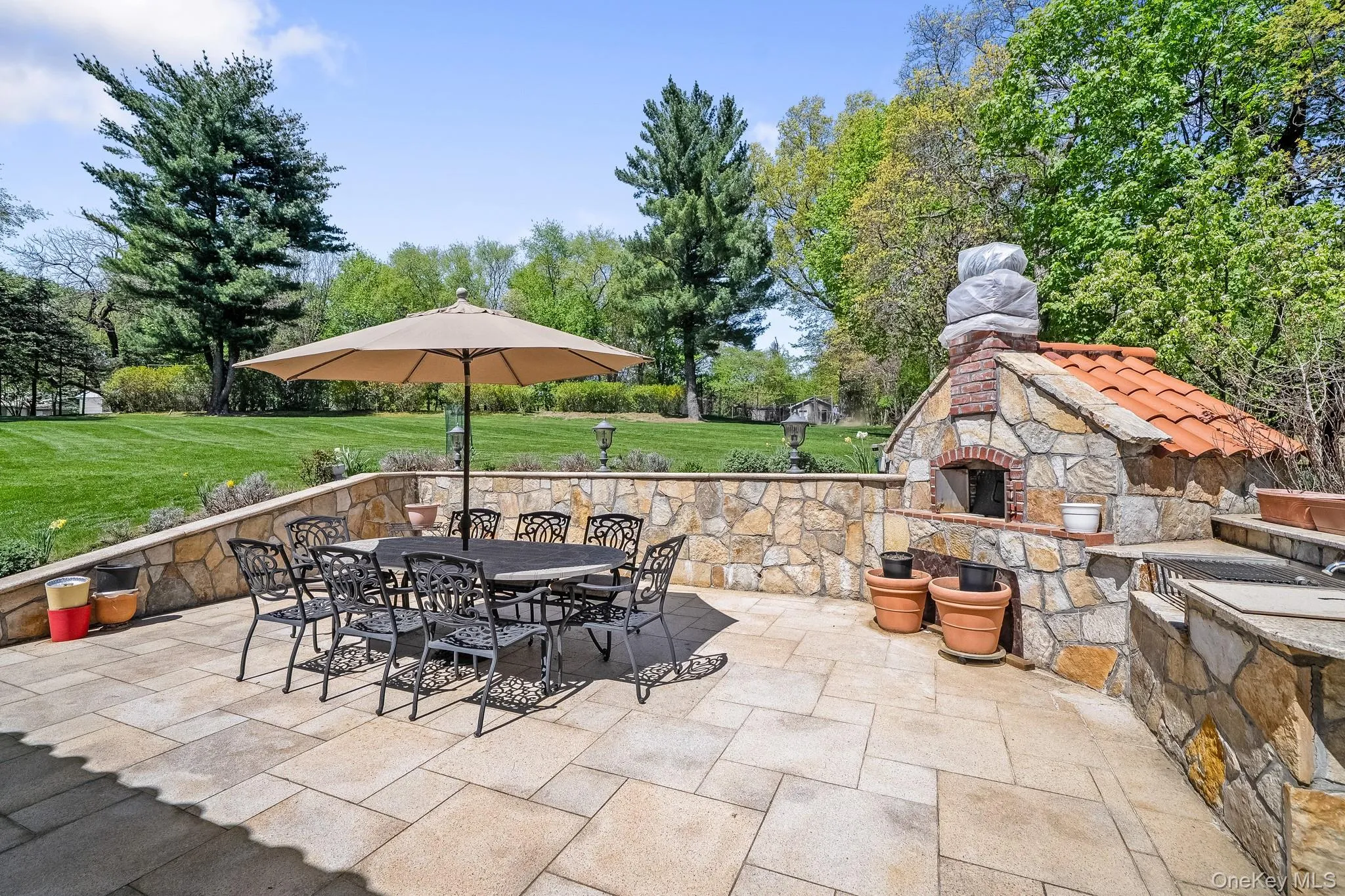 View of patio featuring a fireplace and outdoor dining area View of patio featuring a fireplace and outdoor dining area