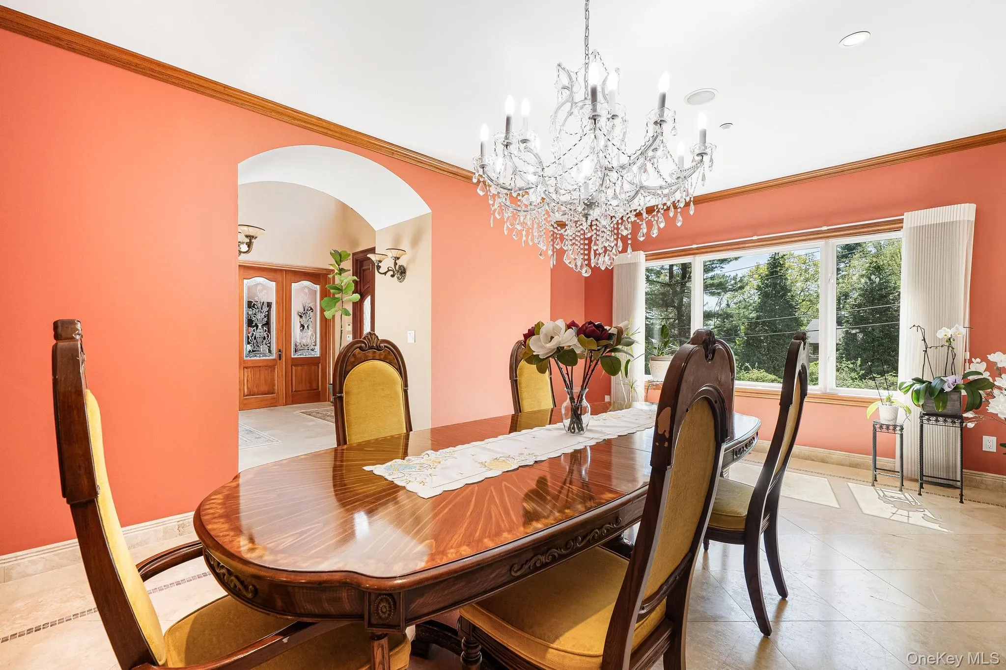Dining area featuring arched walkways, a chandelier, ornamental molding, recessed lighting, and light tile patterned flooring Dining area featuring arched walkways, a chandelier, ornamental molding, recessed lighting, and light tile patterned flooring