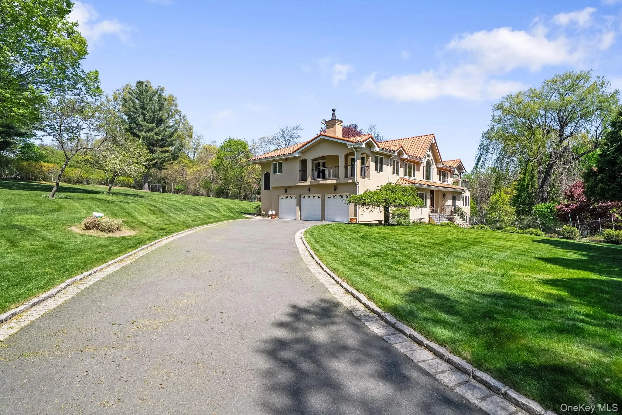Mediterranean / spanish-style home with stucco siding, an attached garage, a chimney, driveway, and a tile roof Mediterranean / spanish-style home with stucco siding, an attached garage, a chimney, driveway, and a tile roof