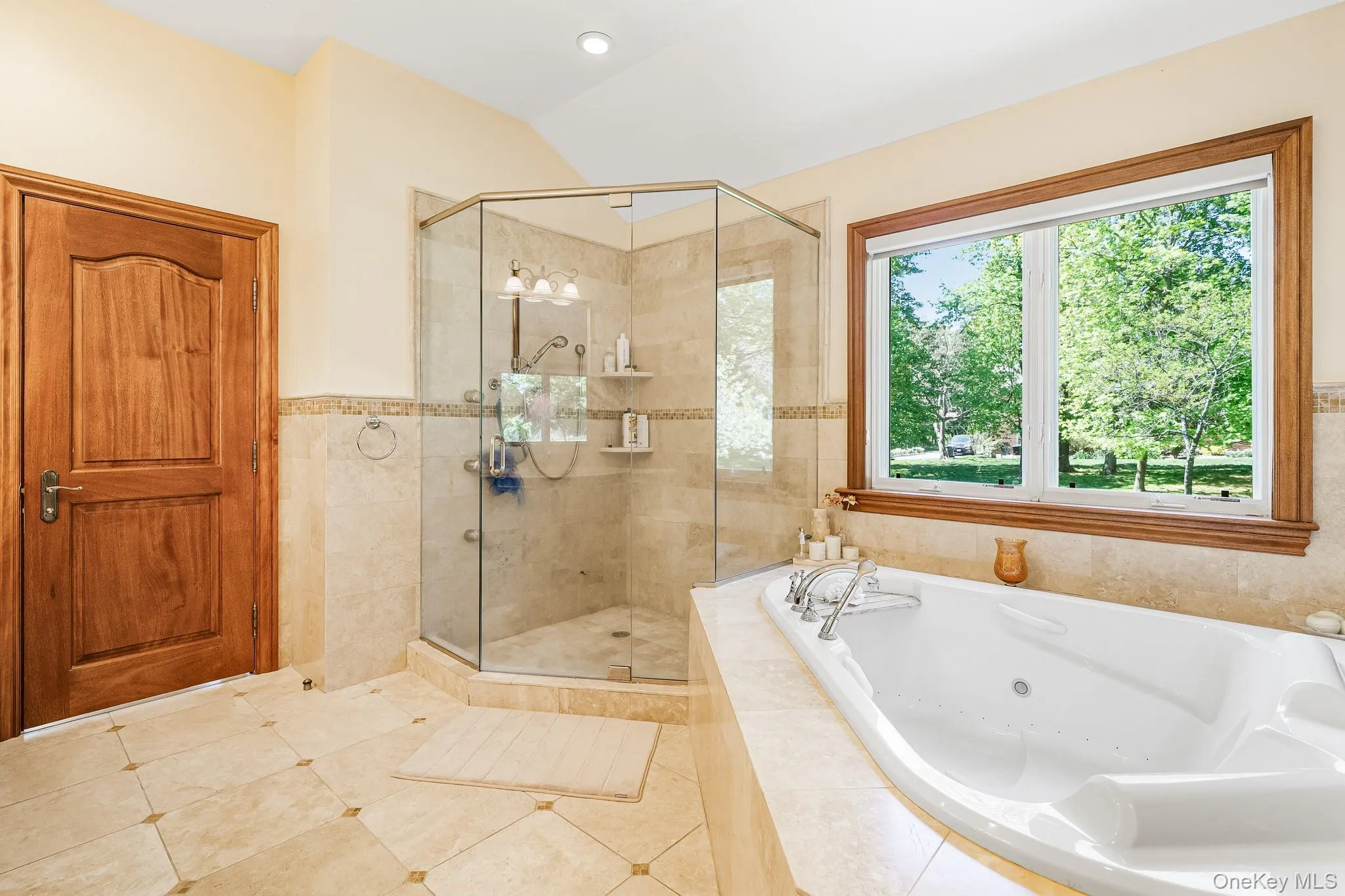 Full bath featuring a jetted tub, a shower stall, tile patterned floors, and lofted ceiling Full bath featuring a jetted tub, a shower stall, tile patterned floors, and lofted ceiling