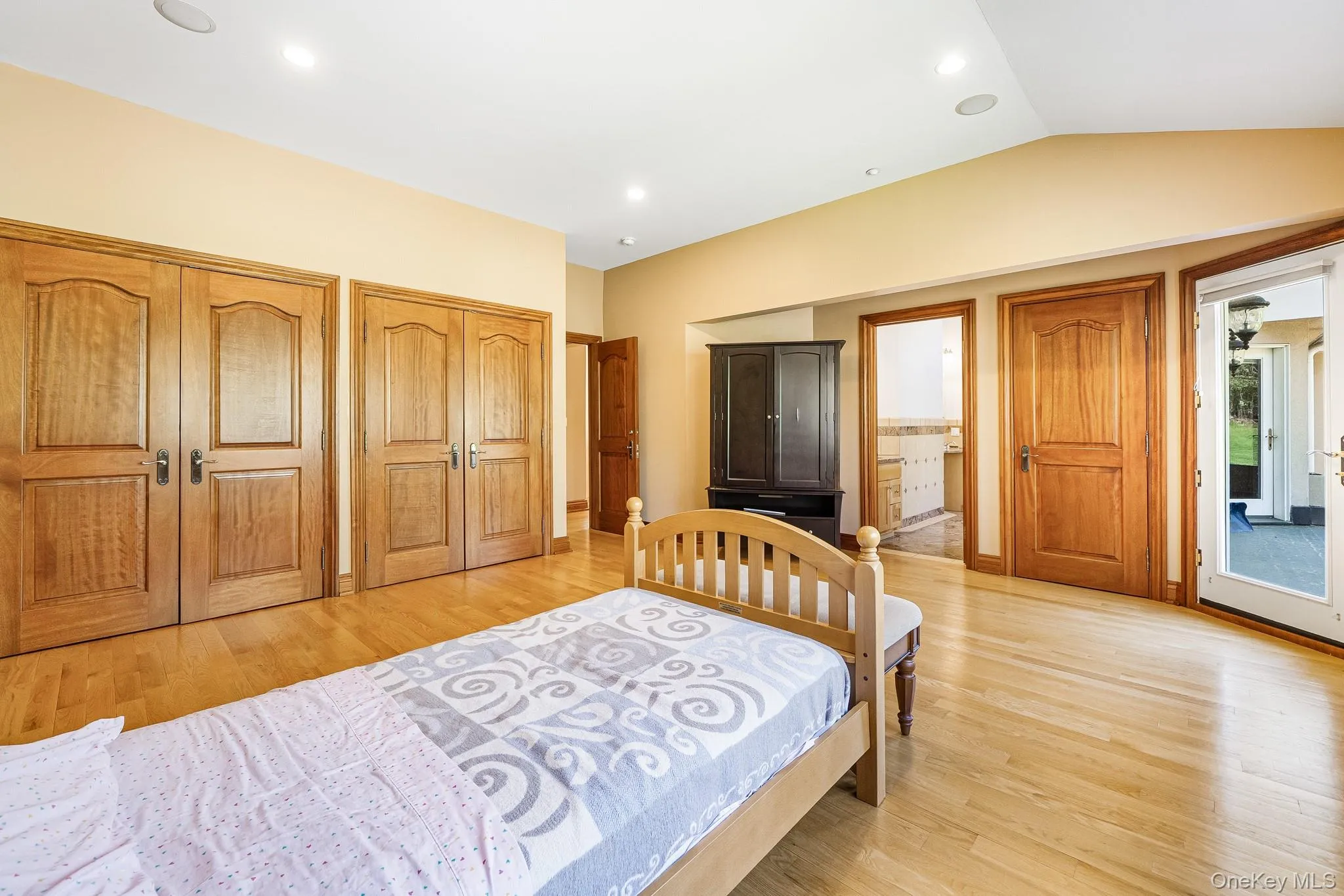 Bedroom with light wood-style floors, multiple closets, lofted ceiling, recessed lighting, and connected bathroom Bedroom with light wood-style floors, multiple closets, lofted ceiling, recessed lighting, and connected bathroom