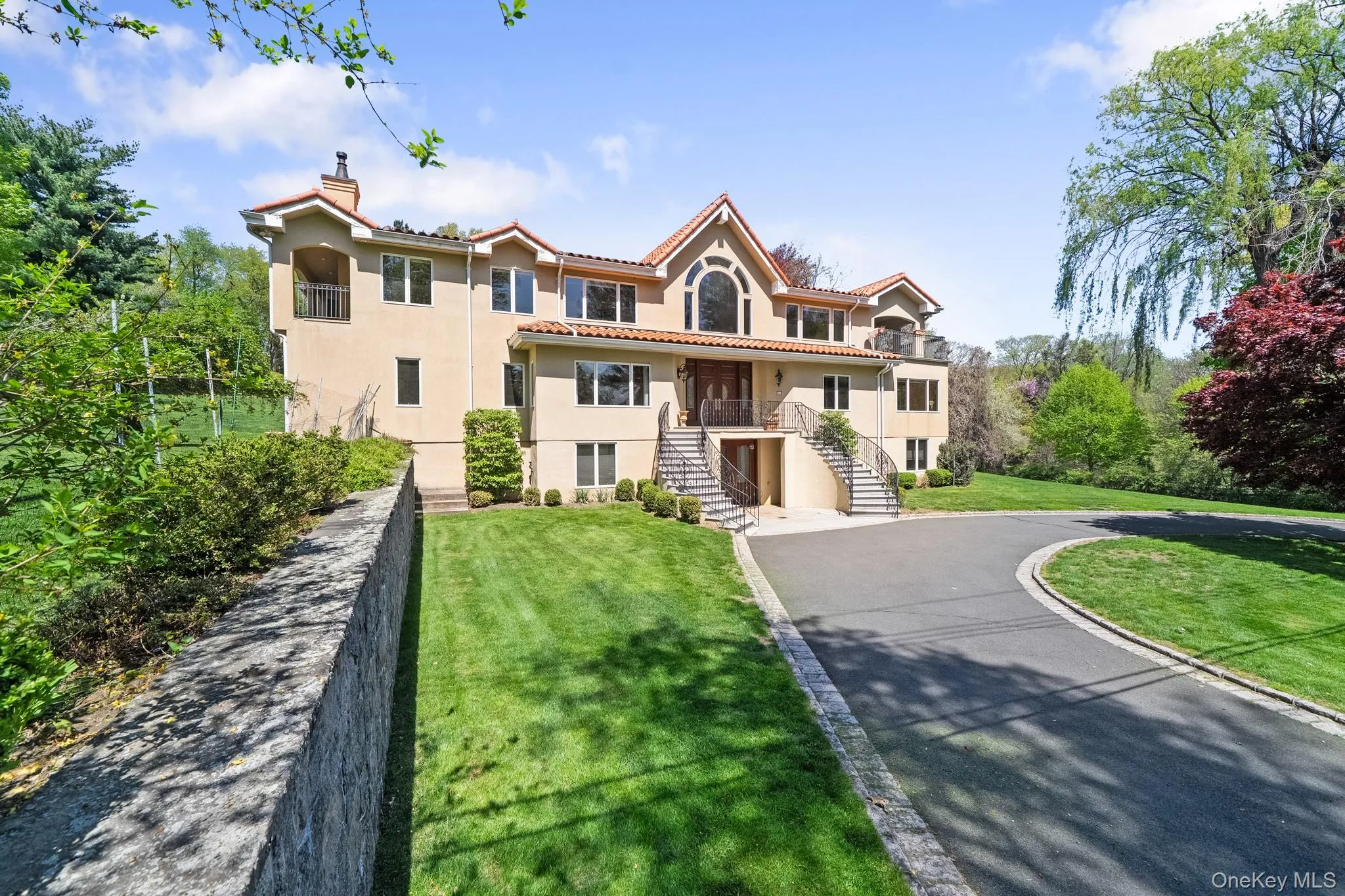 Mediterranean / spanish-style home with stairway, stucco siding, asphalt driveway, a chimney, and a front lawn Mediterranean / spanish-style home with stairway, stucco siding, asphalt driveway, a chimney, and a front lawn