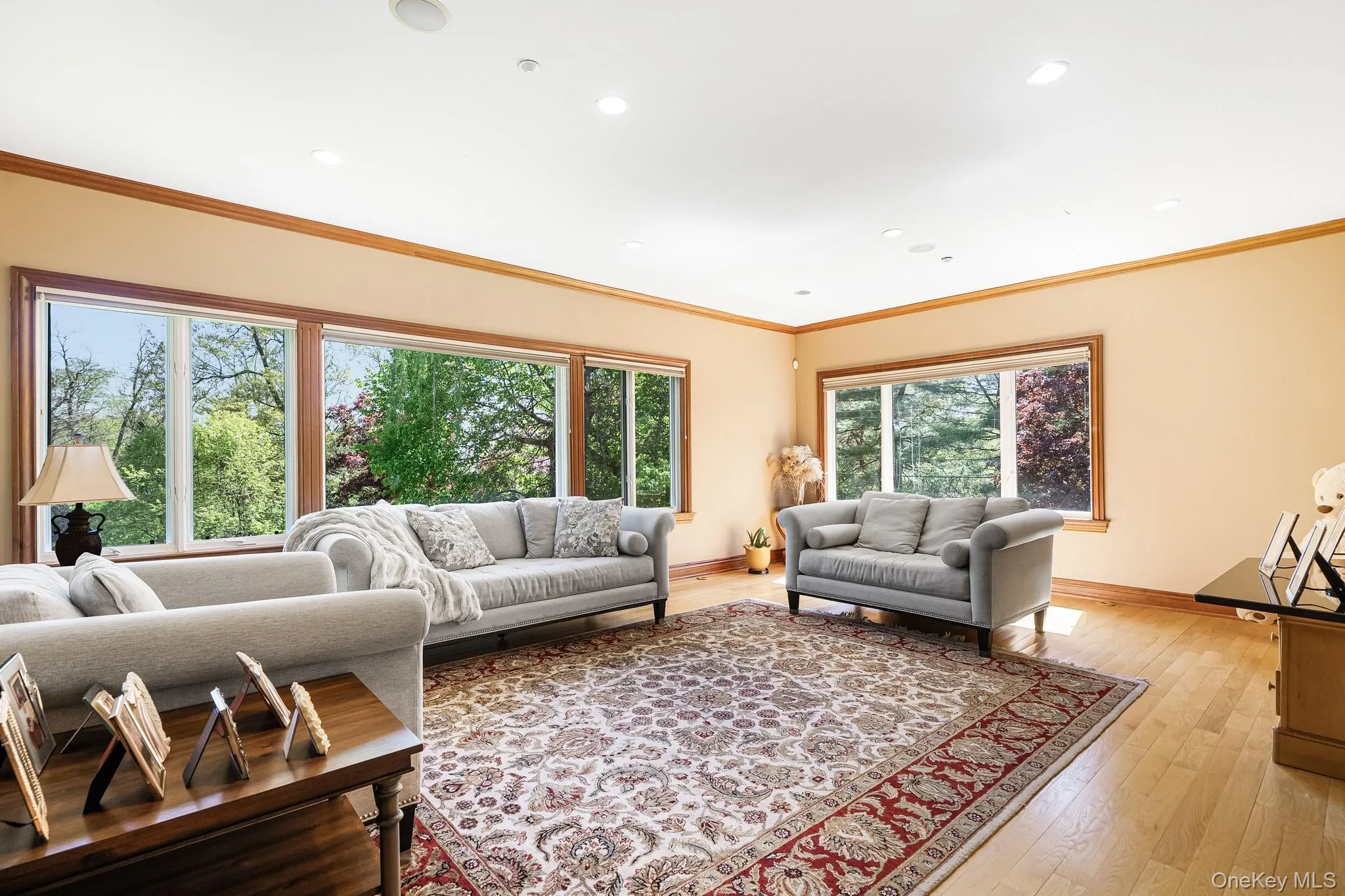Living room featuring light wood-style floors, crown molding, and recessed lighting Living room featuring light wood-style floors, crown molding, and recessed lighting