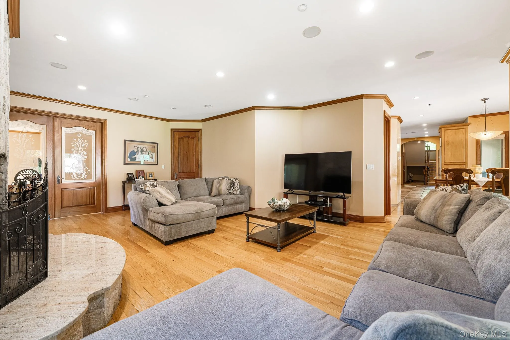 Living area featuring light wood-style flooring, recessed lighting, and crown molding Living area featuring light wood-style flooring, recessed lighting, and crown molding