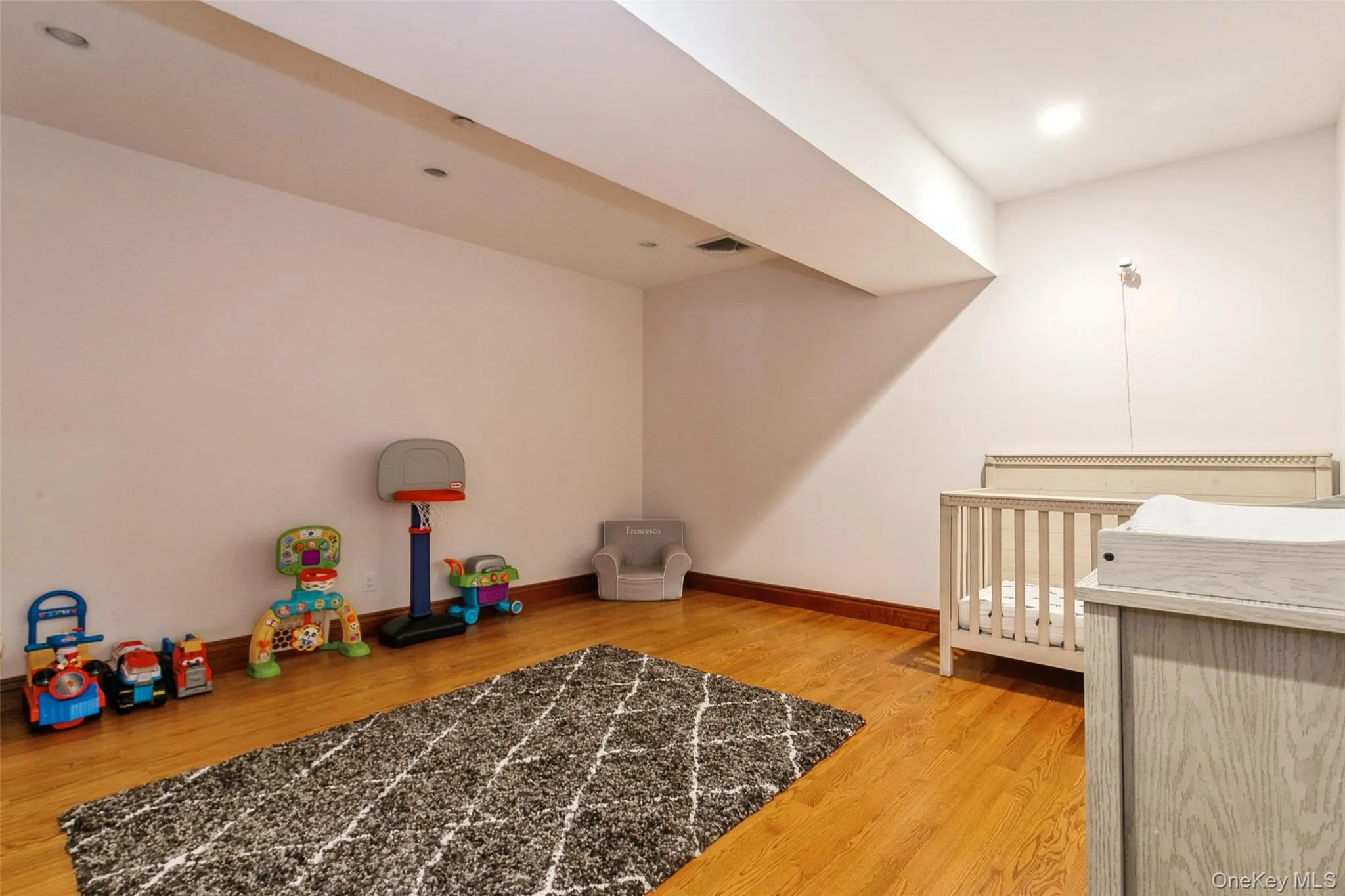 Bedroom featuring wood finished floors and baseboards Bedroom featuring wood finished floors and baseboards