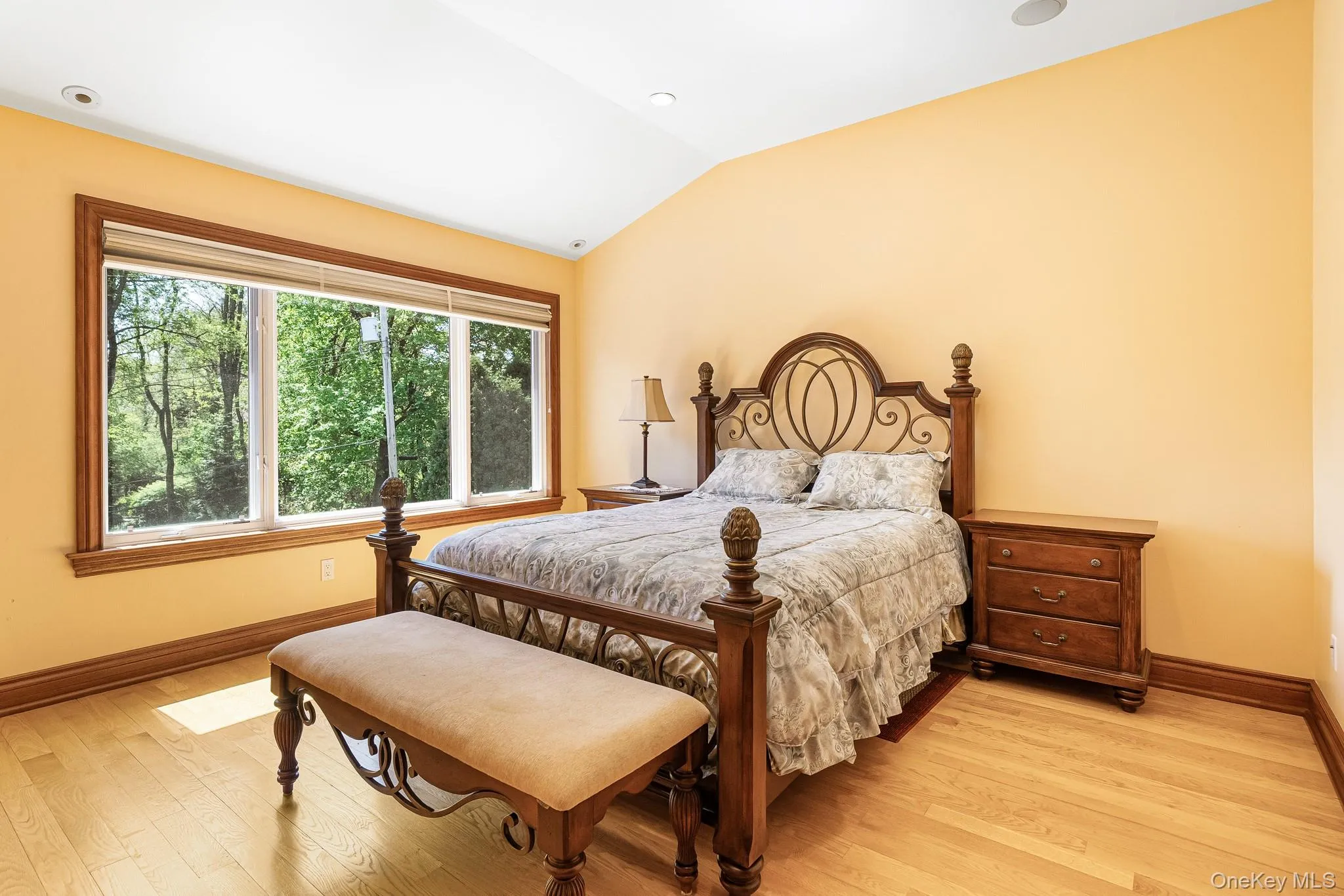 Bedroom featuring vaulted ceiling and light wood-type flooring Bedroom featuring vaulted ceiling and light wood-type flooring