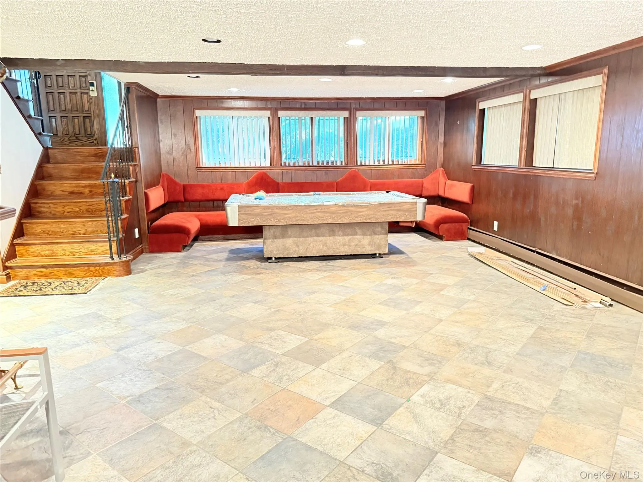 Living area featuring a textured ceiling, wood walls, stairway, and recessed lighting Living area featuring a textured ceiling, wood walls, stairway, and recessed lighting