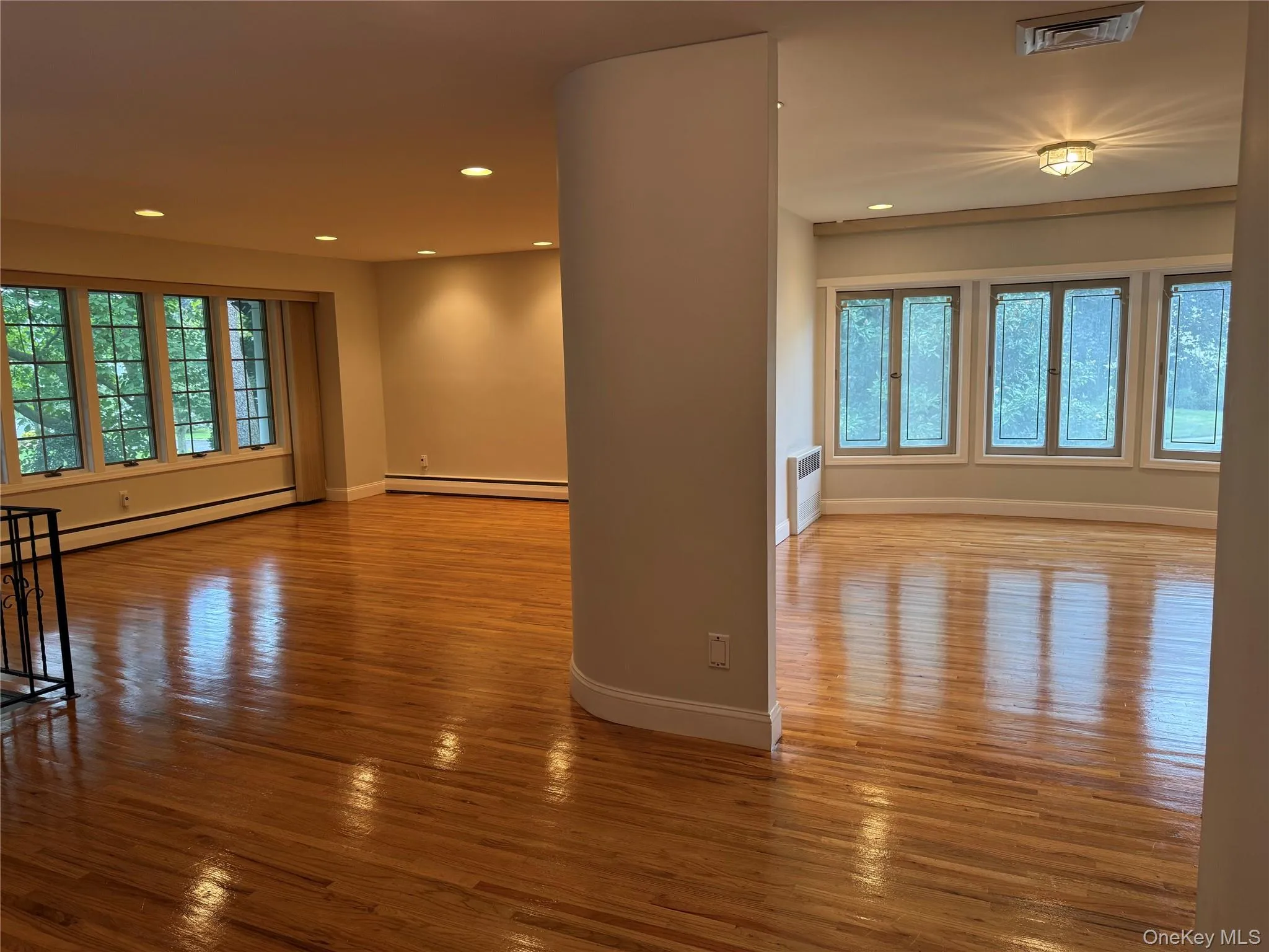 Empty room featuring healthy amount of natural light, light wood-style flooring, recessed lighting, and baseboard heating Empty room featuring healthy amount of natural light, light wood-style flooring, recessed lighting, and baseboard heating