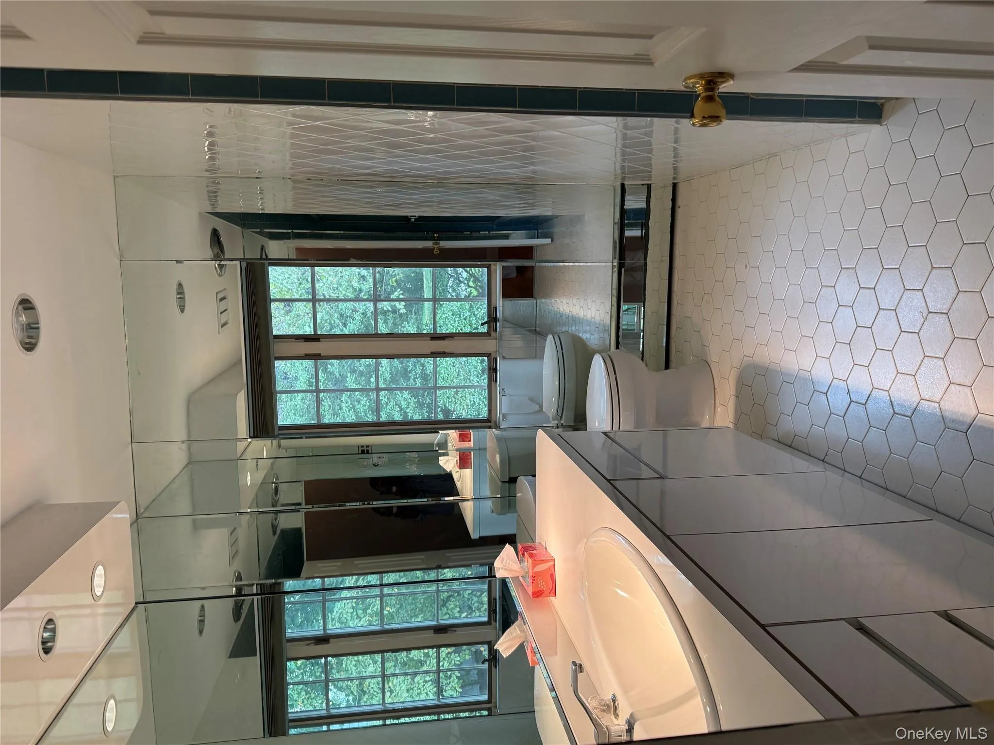 main Full bath featuring vanity, light tile patterned flooring, and tile walls main Full bath featuring vanity, light tile patterned flooring, and tile walls