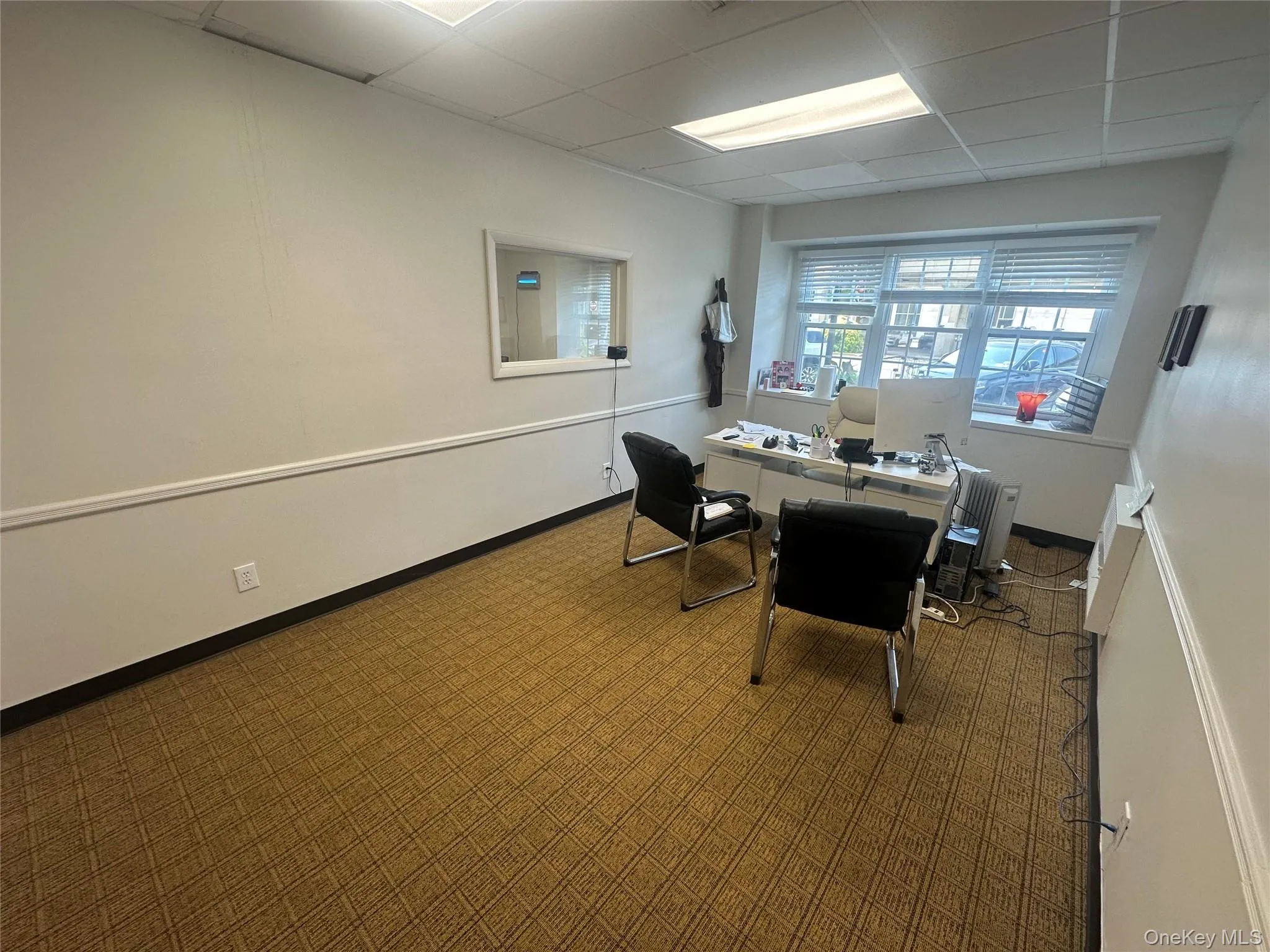 Carpeted office space featuring a paneled ceiling and baseboards Carpeted office space featuring a paneled ceiling and baseboards