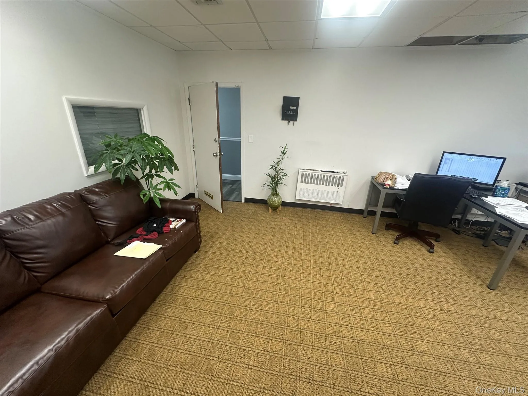 Carpeted office featuring a paneled ceiling and heating unit Carpeted office featuring a paneled ceiling and heating unit